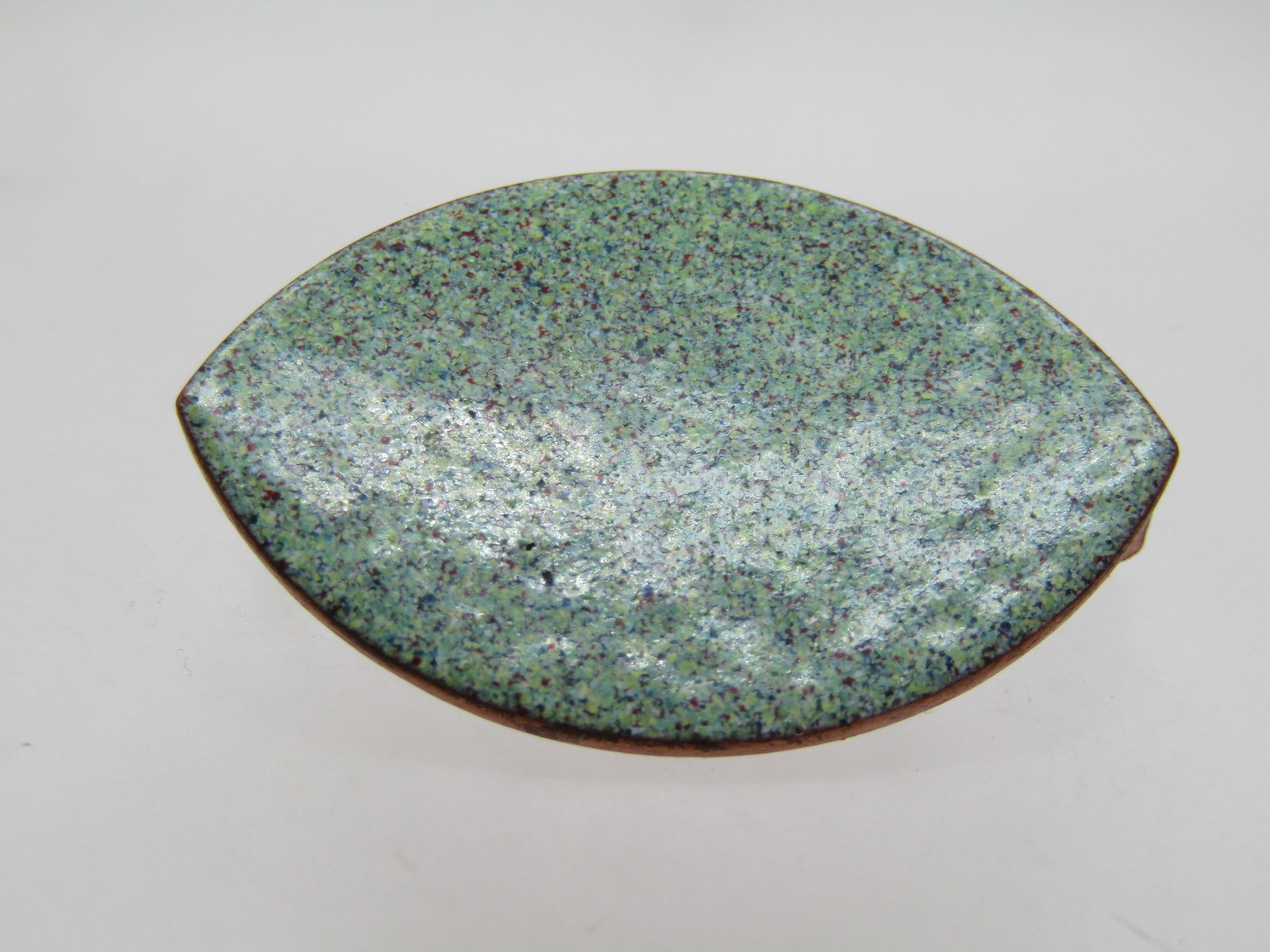 Vintage Enameled Copper Handmade Brooch, 1960's: .Vintage Enameled Copper Handmade Brooch, 1960's. It is cateye shaped with a light green speckled enameled finish. The colors are red, yellow, shades of green and blue.. It is appx. 1.5" wide and