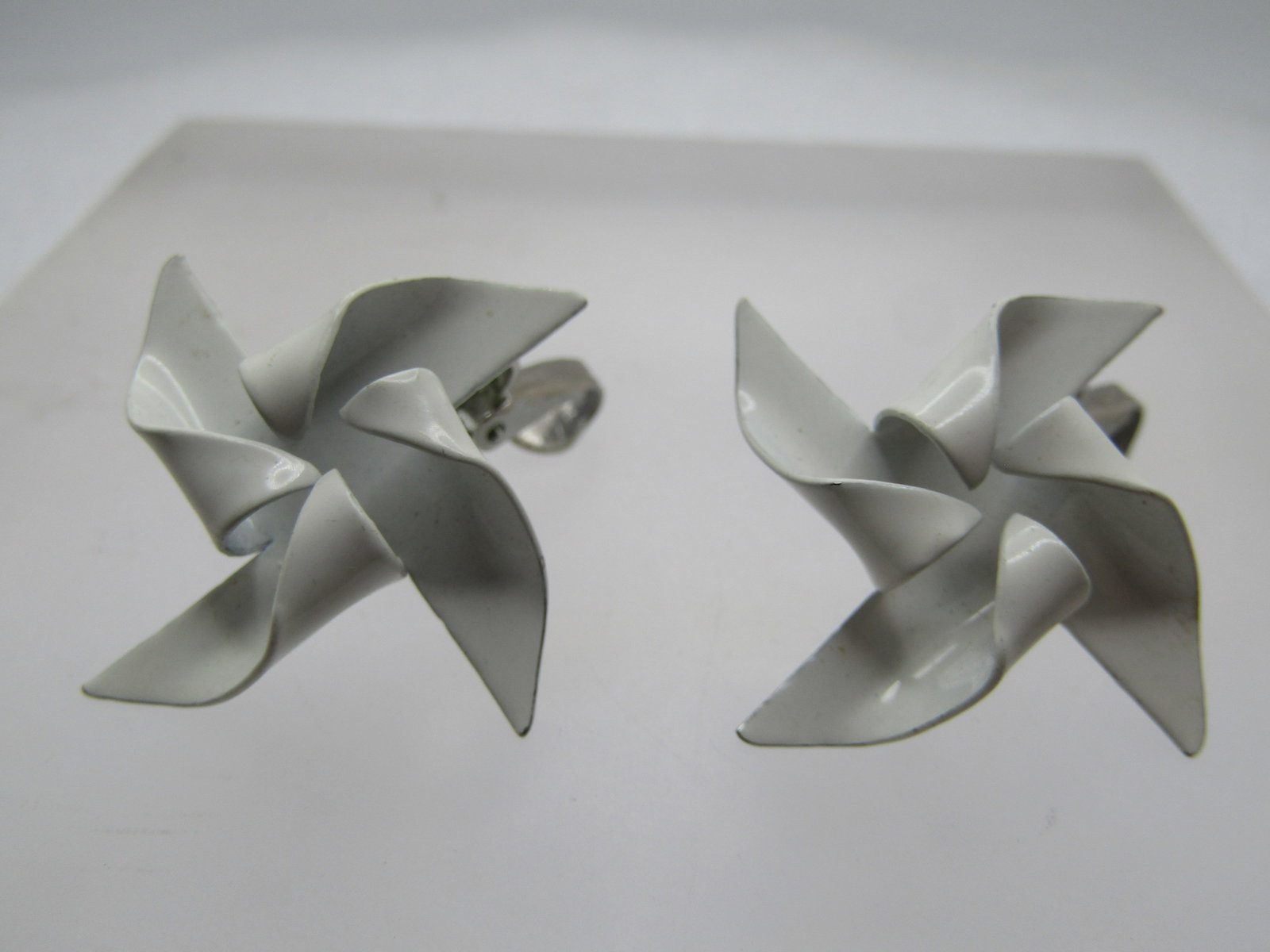 Vintage White Enameled Pinwheel Earrings, Clip, 1950's-1960's: Vintage White Enameled Pinwheel Earrings, Clip, 1950's-1960's. White enameling over silver tone metal. They are appx. 1.25" wide. They are not marked or signed. Very good condition. (W12024.2