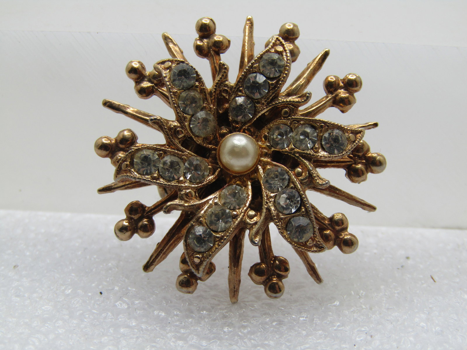 Vintage Tiered Rhinestone Blossom Brooch, Faux Pearl, 1950's-1960's: Vintage Tiered Rhinestone Blossom Brooch, Faux Pearl, 1950's-1960's. Gold tone with a center appx. 3mm faux pearl and petals with three cear rhinestones in each that are appx. 2.5mm. Below that are ra