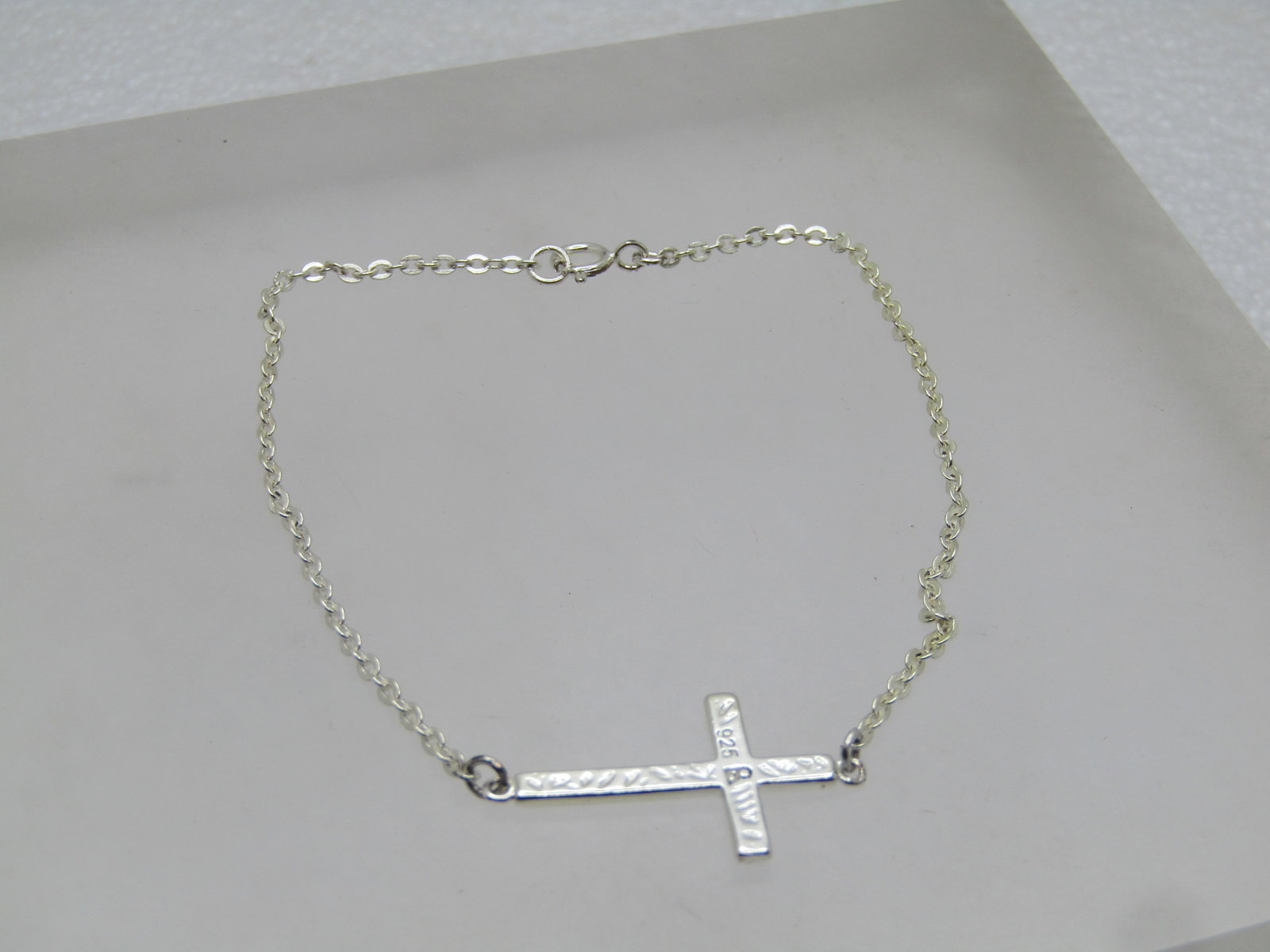 Sterling Cross Bracelet, 7.5", 1" Cross, 2000's: Sterling Cross Bracelet, 7.5", 1" Cross, 2000's. The cross is centered on the bracelet with a decorate design front and back and signed .925 which may also be signed R. Very cleand and in very