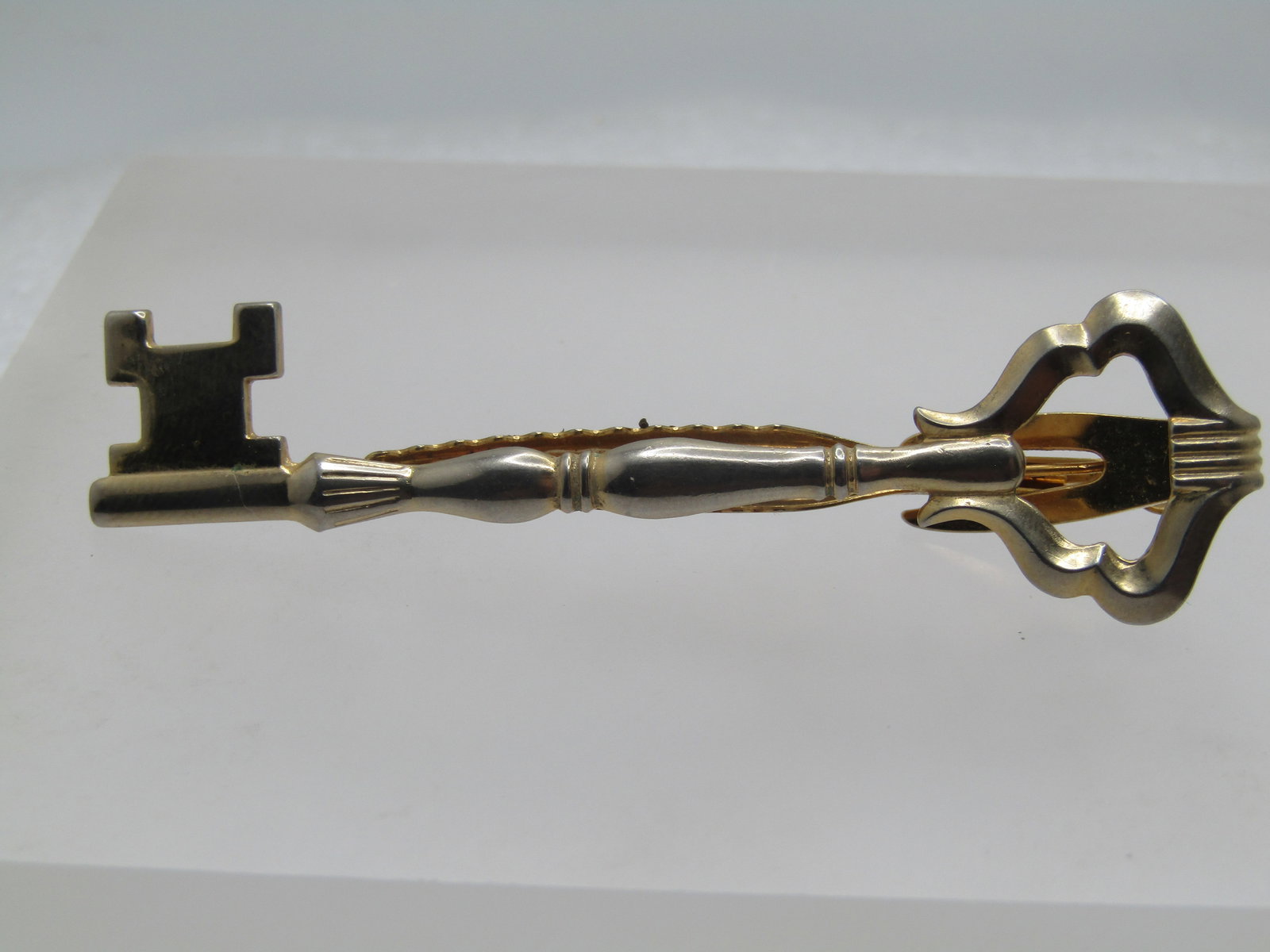 Vintage Long Key Tie Clasp, Signed Hickok, 1960's: Vintage Long Key Tie Clasp, Signed Hickok, 1960's This is appx. 3" long and 3/4" tall at the handle end of the key and 1/2" at the other. Gold tone. Signed Hickok USA. Very good condition.