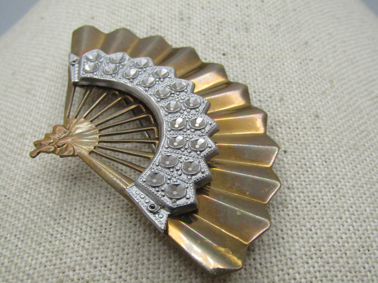 Vintage Two-Tone Fan Brooch, 1940's-1950's: Vintage Two-Tone Fan Brooch, 1940's-1950's. The fan is gold tone with a siler tone illusion setting accent on front. It is appx. 3" wide and 2" tall. Locking clasp. It is not signed or marked. Light t