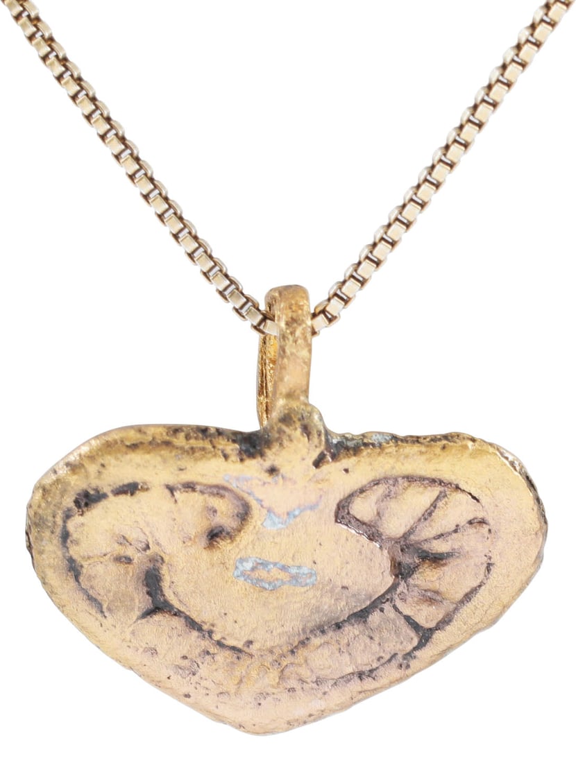 VIKING HEART PENDANT, 10TH-11TH CENTURY, DANELAW ENGLAND: Just over 1/2” (0.57”) height. Gilt bronze of stylized form with cusped top. The field with a second stylized heart in radiant field. For Vikings, the heart stood for bravery, fortitude,