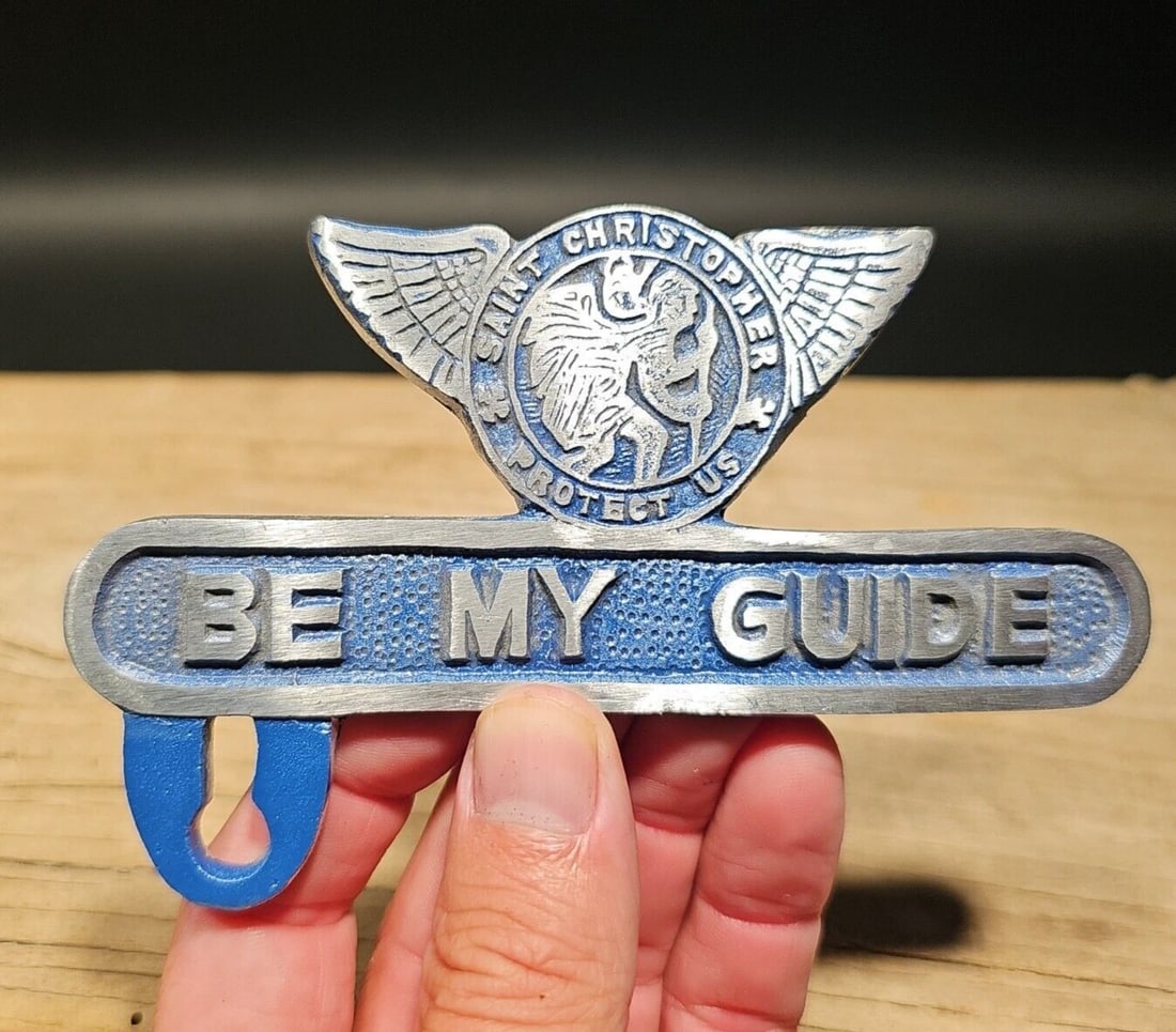 St. Christopher Plate Fob Topper: 5 1/8" Wide x 3 1/4" Tall Wonderful reproduction safety license plate topper. Good detail aluminum, slightly aged to look like an antique. Certainly hard to tell its age. Reserve: $15.00 Shipping: Dom