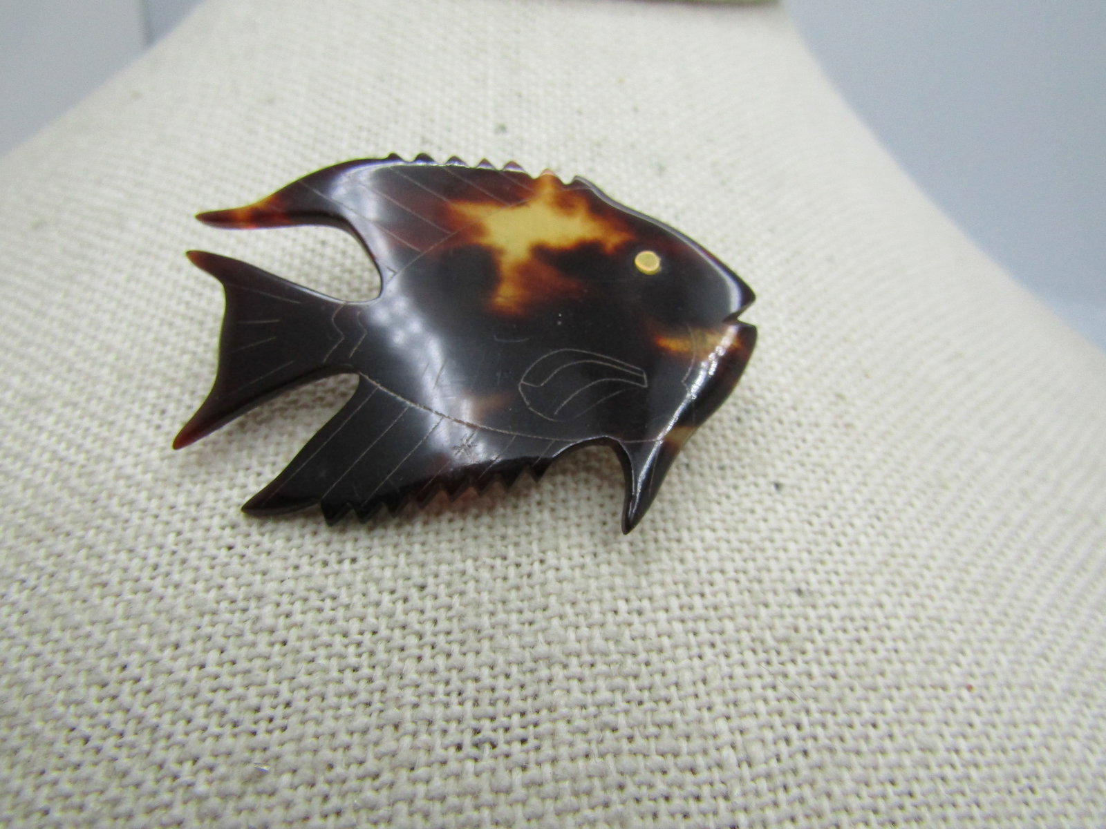 Vintage Tortoiseshell Fish/Shark Tack Pin, 1960's-1970's: Vintage Tortoiseshell Fish Brooch 1960's-1970's. 1.75" wide and 1.25" tall with etched detail lines on the tail, and fins with a brass eye. It is not signed or marked. Very good condition.