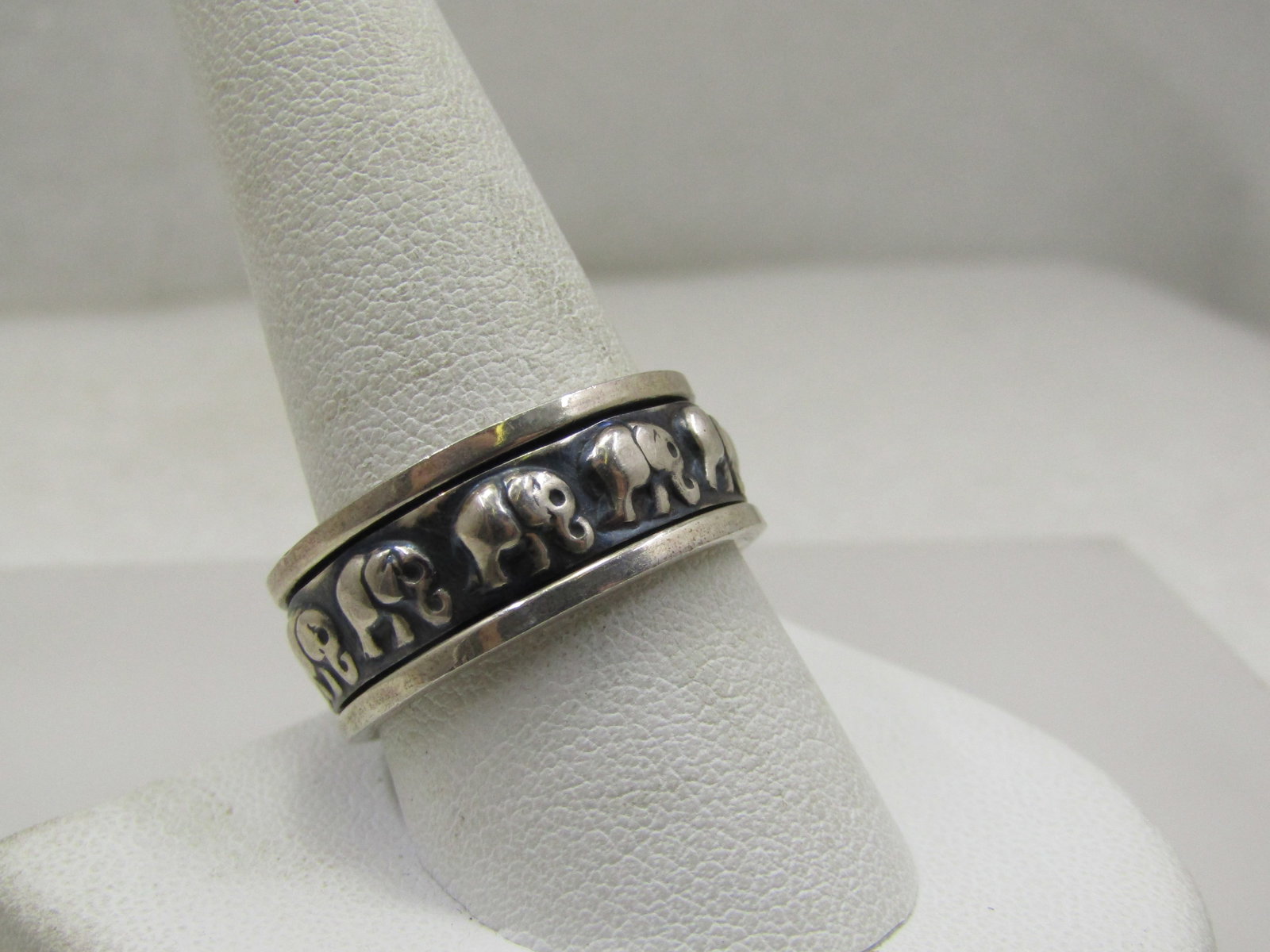 Vintage Sterling Silver Spinner Elephant Ring, Unisex, Sz. 11: Vintage Sterling Silver Spinner Elephant Ring, Unisex, Sz. 1, 9mm wide with a recessed center with black background spinner that has repousse elephants marching around the band. Age is estimated at