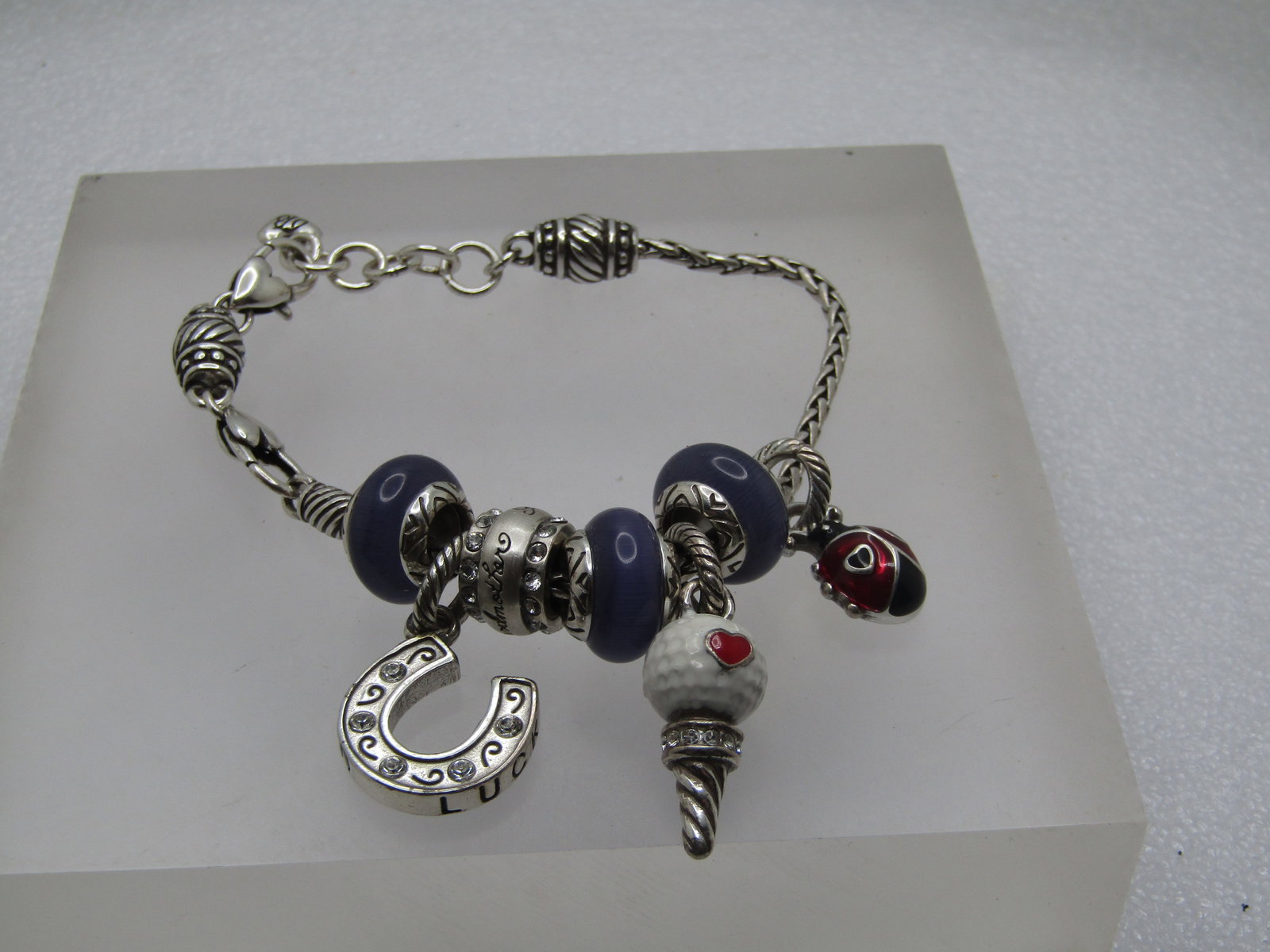 Vintage Brighton Slide Charm Bracelet, 8", Grandmother Golf Ball on tee, Purple Glass, Lucky: Vintage Brighton Slide Charm Bracelet, 8", Grandmother Golf Ball on tee, Purple Glass, Lucky Horseshoe, Lady Bug, 1990's. The chain is a fox tail style cahin with three purple cateye glass slide