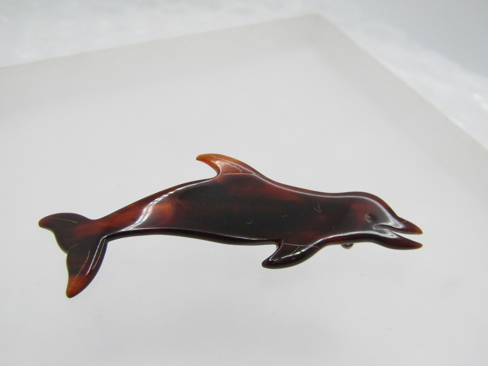 Vintage Tortoiseshell Dolphin Brooch, Carved 1960's: Vintage Tortoiseshell Dolphin Brooch, Carved 1960's. Carved details in the fins and tail and beak, and is 2.25" wide and 3/4" from top fin to bottom fin. It is not totally flat - it has some shape