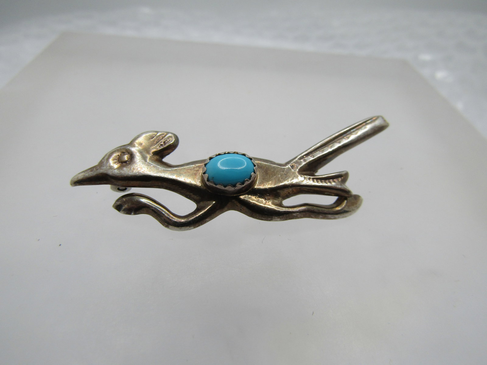 Vintage Sterling Southwestern Turquoise Roadrunner Brooch, 1960's-1970's. 2": Vintage Sterling Southwestern Turquoise Roadrunner Brooch, 1960's-1970's. 2" wide and 1" tall at the tall to the feet. It has an oval sleeping beauty sawtooth bezel-set turquoise stone that is appx.