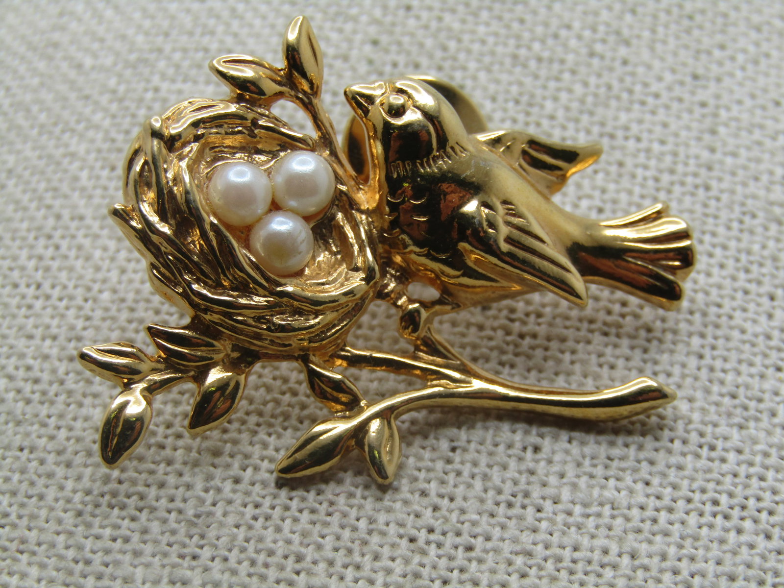 Vintage Bird and Nest Tack Pin, Faux Pearls, 1980's-1990's: Vintage Bird and Nest Tack Pin, Faux Pearls, 1980's-1990's. Gold tone with a bird sitting on a branch looking over her three faux pearl eggs. The nest is nestled between the limbs on a branch. It