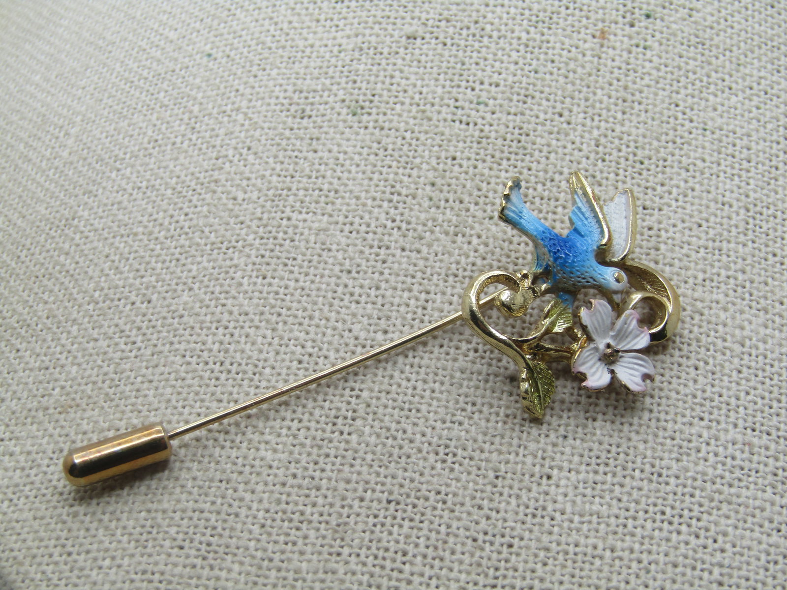 Vintage Enameled Blue Bird Dogwood Stick Pin, 1960's-1970's, 2-5/8": Vintage Enameled Blue Bird Dogwood Stick Pin, 1960's-1970's, 2-5/8" with Safety Cap. The bird is enameled in shades of blue and white with a white dogwood blossom and gold tone scrolls. It is not