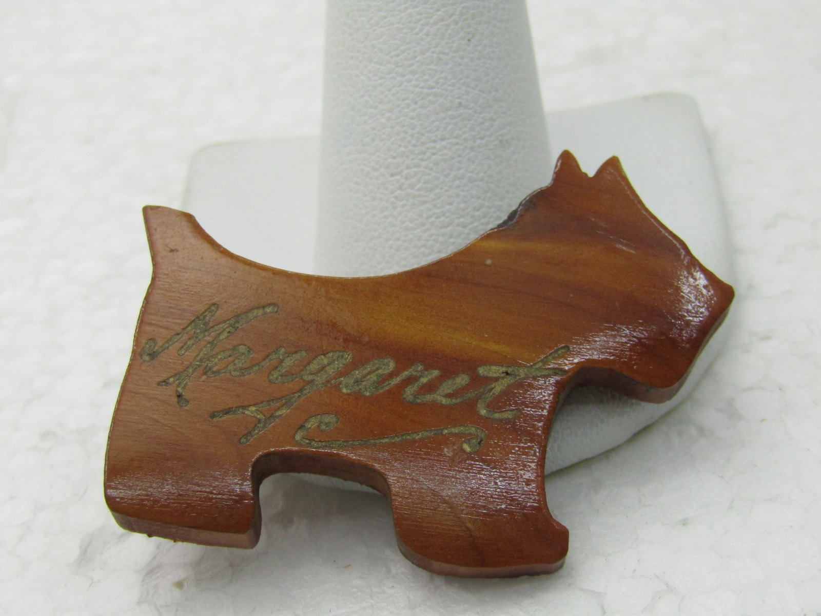 Vintage "Margaret" Wooden Scotty Dog Brooch, Name is in Gold Script.: Vintage "Margaret" Wooden Scotty Dog Brooch, Name is in Gold Script. 1950's wooden't Scotty Dog cut-out with Margaret written in gold along with a few accent scrolls. 2" wide and 1.5" tall. Very good