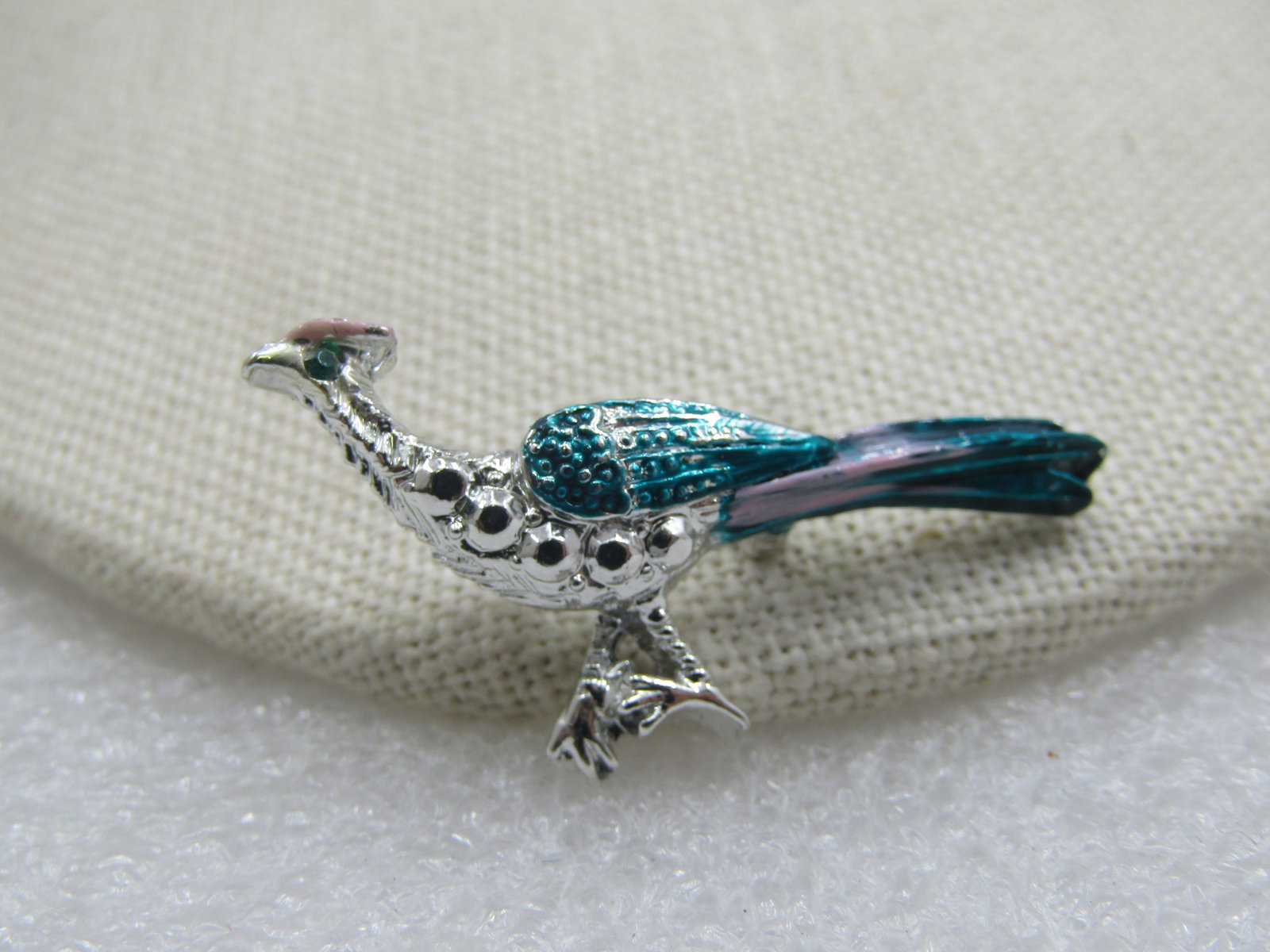 Vintage Enameled Peacock Brooch, 1.5": Vintage Enameled Peacock Brooch, 1.5" by 1", sivler tone with green rhinestone eye. Age is appx. 1960's. Very good condition, not signed by the maker. (W11321.3 SS6683 AZ LEB* LD 3/2/22). Reserve: $20