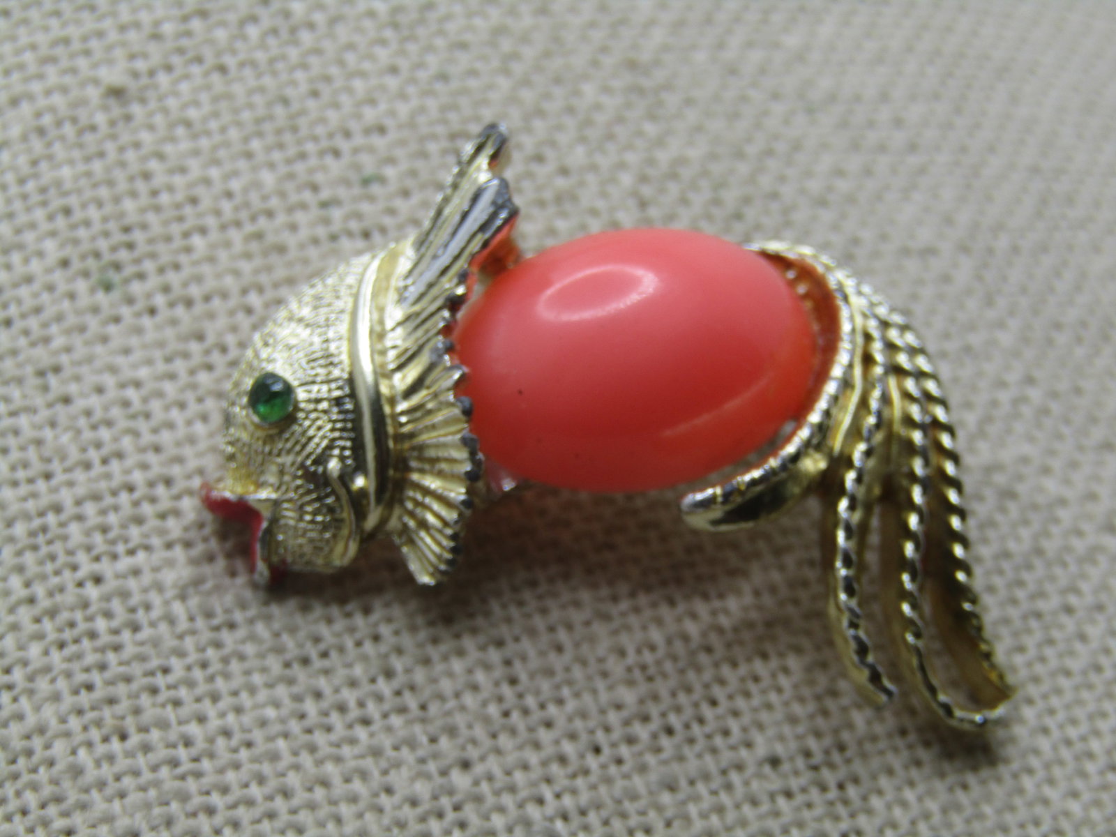 Vintage Fancy Fish Brooch, 1960's, 1.5" Wide: Vintage Fancy Fish Brooch, 1960's, 1.5" Wide and 1" tall. Gold tone with smooth and textured accents. The lips of the fish are enameled in red with a green rhinestone eye and a coral colored plastic c