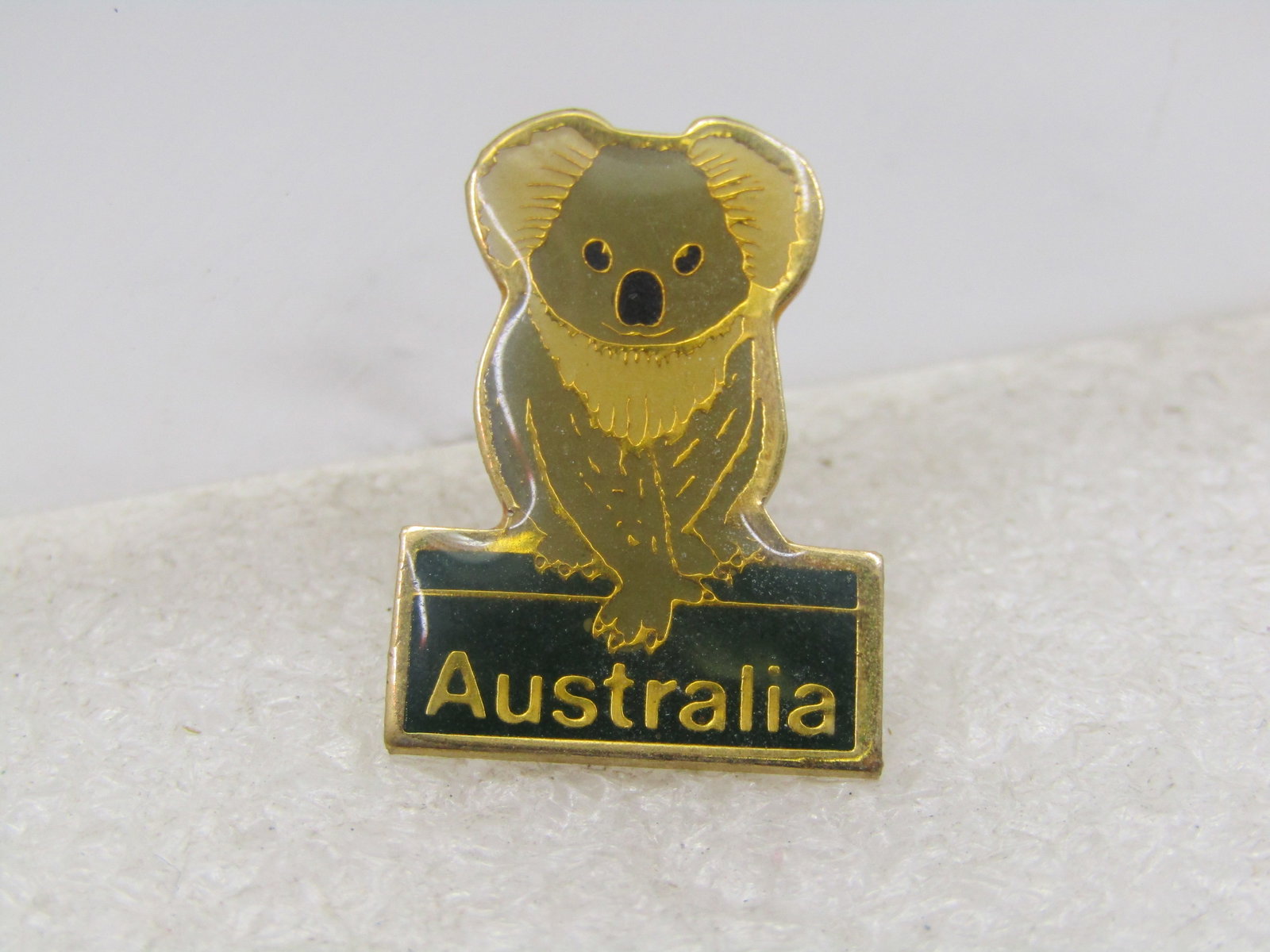 Vintage Australia Koala Souvenir Brooch, Enameled: Vintage Australia Koala Souvenir Brooch, Enameled. It has the koala on top with Australia on the bottom over a green background with gold lettering. Signed Nu-Color-Vue. Very good condition. 
