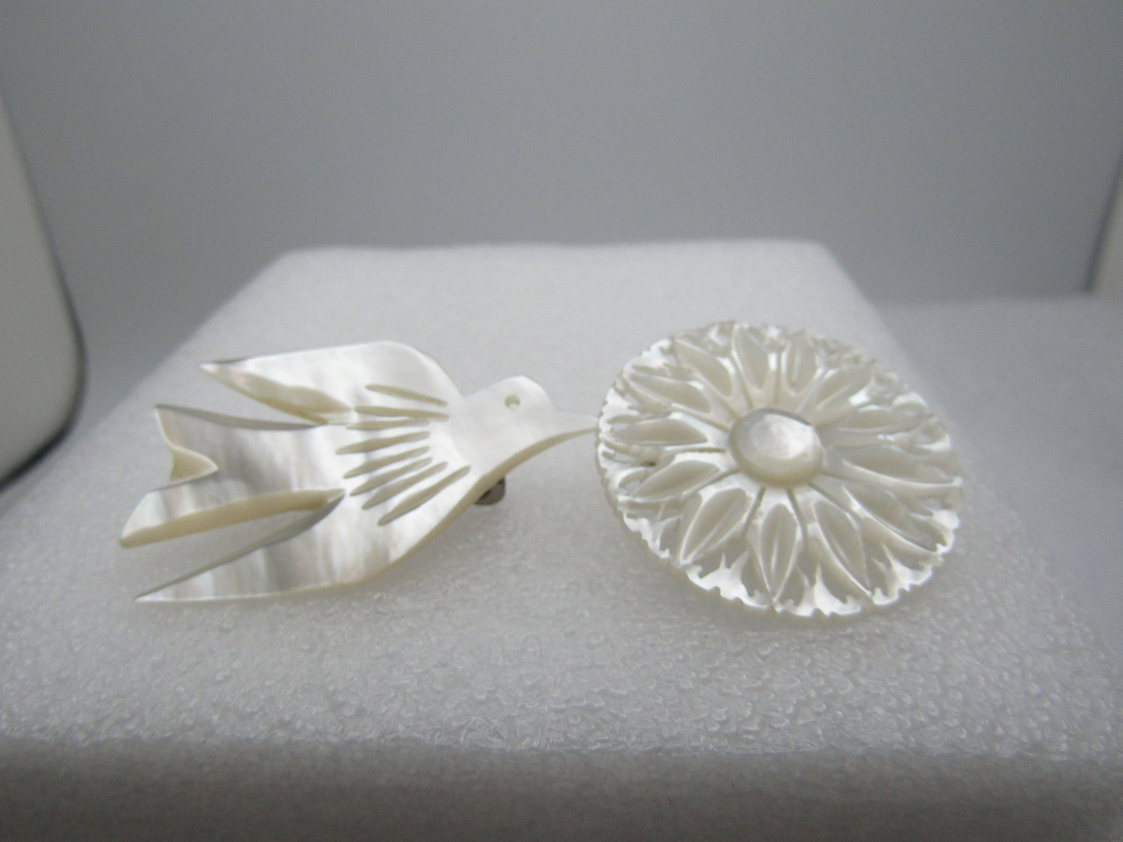 Vintage Pair of Carved MOP Brooch, Blossom & Dove, 1960's-1970's: Vintage Pair of Carved MOP Brooch, Blossom & Dove, 1960's-1970's. A round pointed blossom with founded center and filigree base frame. It is appx. 1.25" across, silver tone locking clasp. The