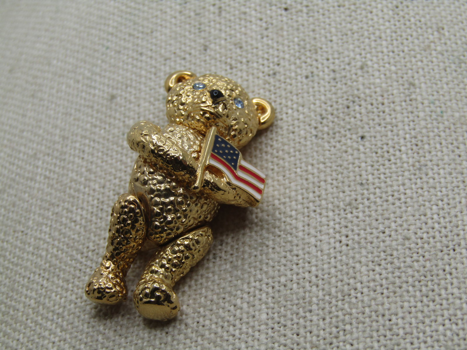 Vintage Napier Jointed Bear Brooch with U.S.A. Flag, 1980's: Vintage Napier Jointed Bear Brooch with U.S.A. Flag, 1980's. It is appx. 1.5" tall, slightly over and 3/4" wide at the widest pint. The flag is enameled. Legs are jointed. Signed Napier. Gold