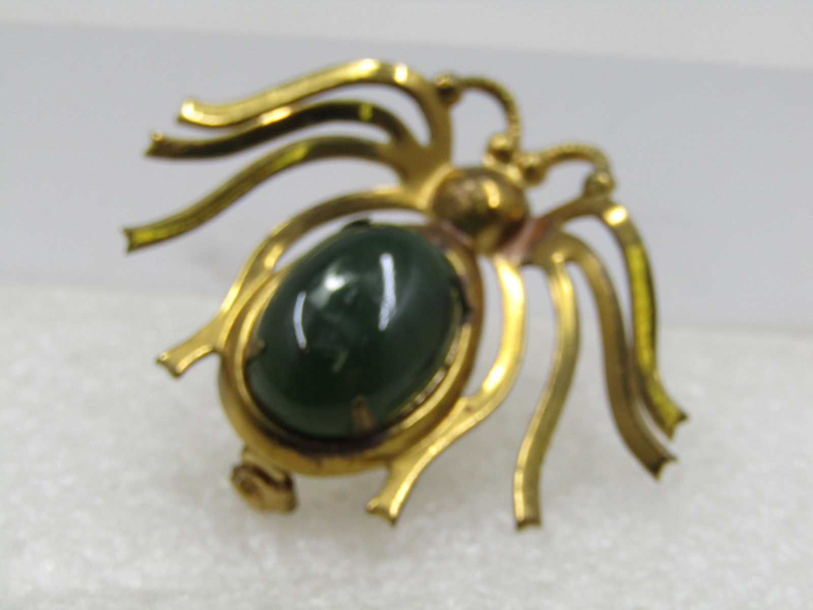 Vintage Jadeite Spider Brooch, 1950's-1960's: Vintage Jadeite Spider Brooch, 1950's-1960's. Gold tone spider with a 17.5mm by 12.5mm oval jadeite torso. Gold tone metal. Not signed by the maker. Very good condition. (W71622.8 SS7936 J LD