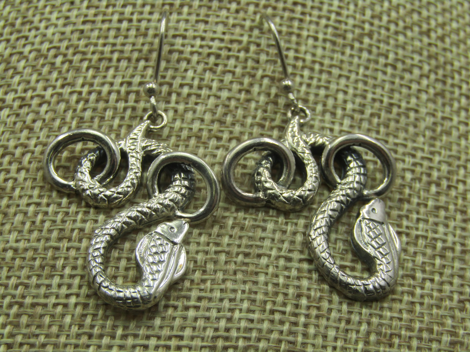 Sterling Silver Snake Pierced Earrings, 1.75": Sterling Silver Snake Pierced Earrings, 1.75"Long and 1" wide. Marked .925, tested Weight is appx. 8.14 gr. The textured designed snake is coiled and moving in and out of two ring. Very good
