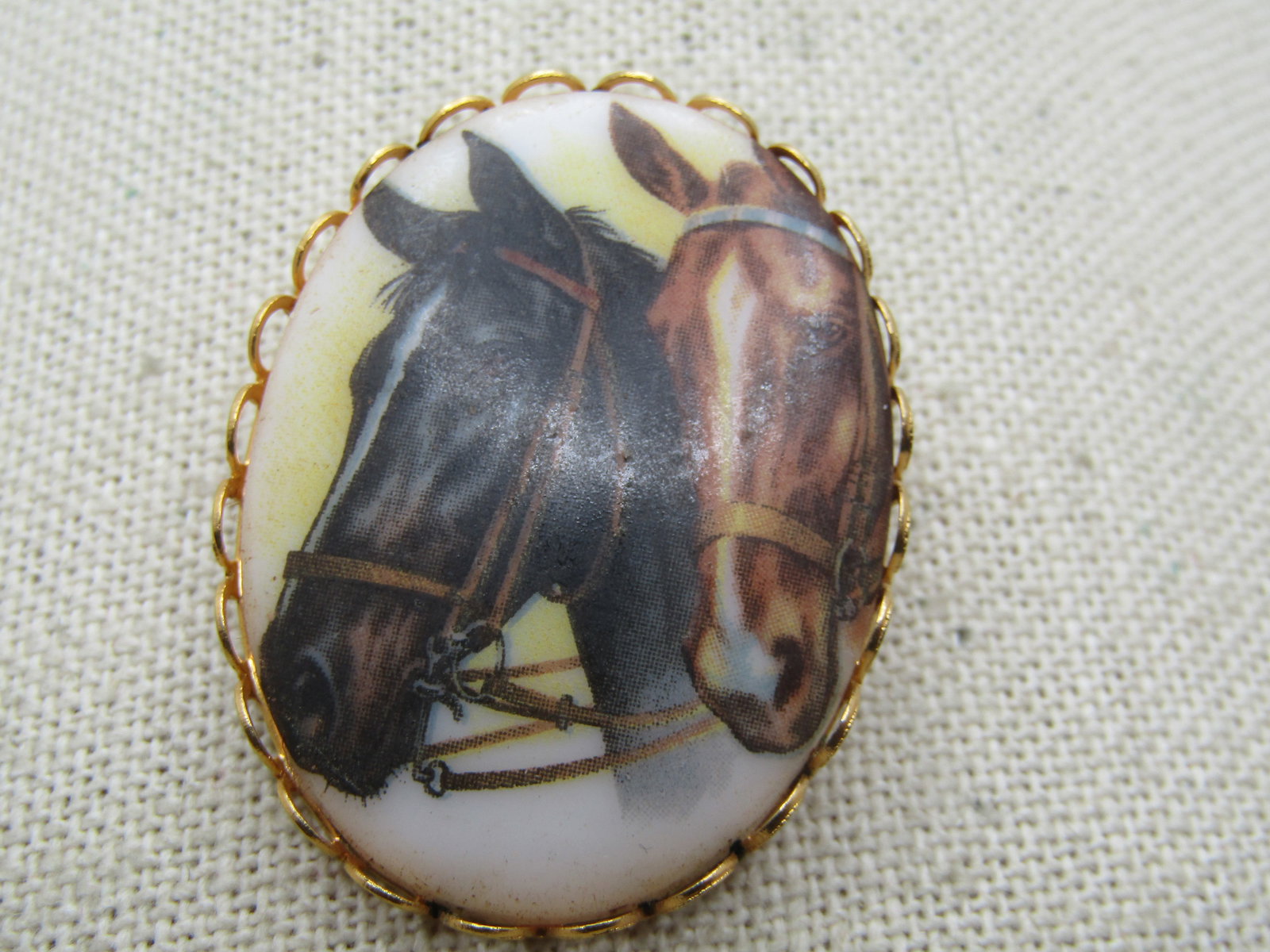 Vintage Horses Cameo Style Brooch, 1960's-1970's: Vintage Horses Cameo Style Brooch, 1960's-1970's. Gold tone with scalloped bezel frame. it is appx. 1.75" tall and 1.25" wide. Locking clasp. Very good condition. Not signed by the maker.