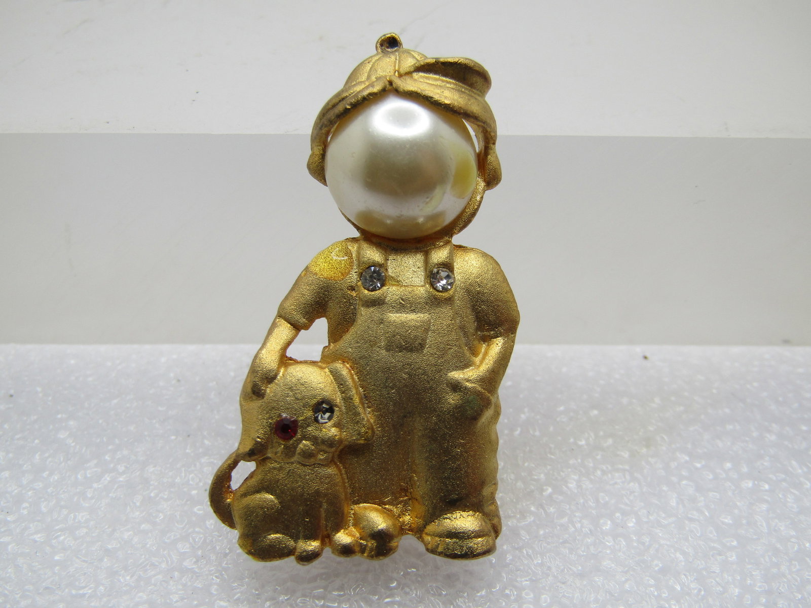 Vintage Farmer with his Dog Brooch, Faux Pearl/Rhinestones, 1970's-1980's: Vintage Farmer with his Dog Brooch, Faux Pearl/Rhinestones, 1970's-1980's. Satin gold tone finish with a farmer with a faux pearl that is appx. 11mm round wearing overalls with rhinestone buttons and