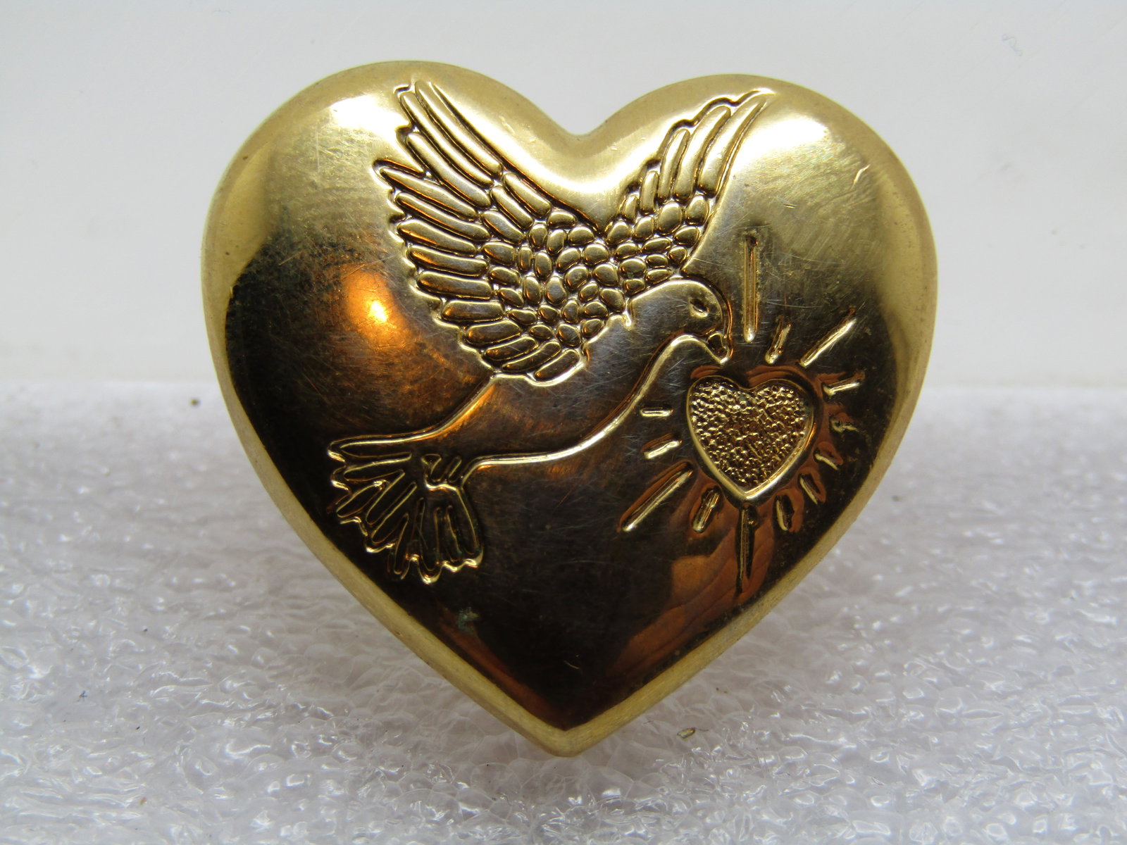 Vintage Variety Club Heart Dove Peace Brooch, 1997: Vintage Variety Club Heart Dove Peace Brooch, 1997. the heart is appx. 1" by 1", slightly domed and is gold done with a dove carrying a recessed heart with rays. Very good condition. Signed Variety