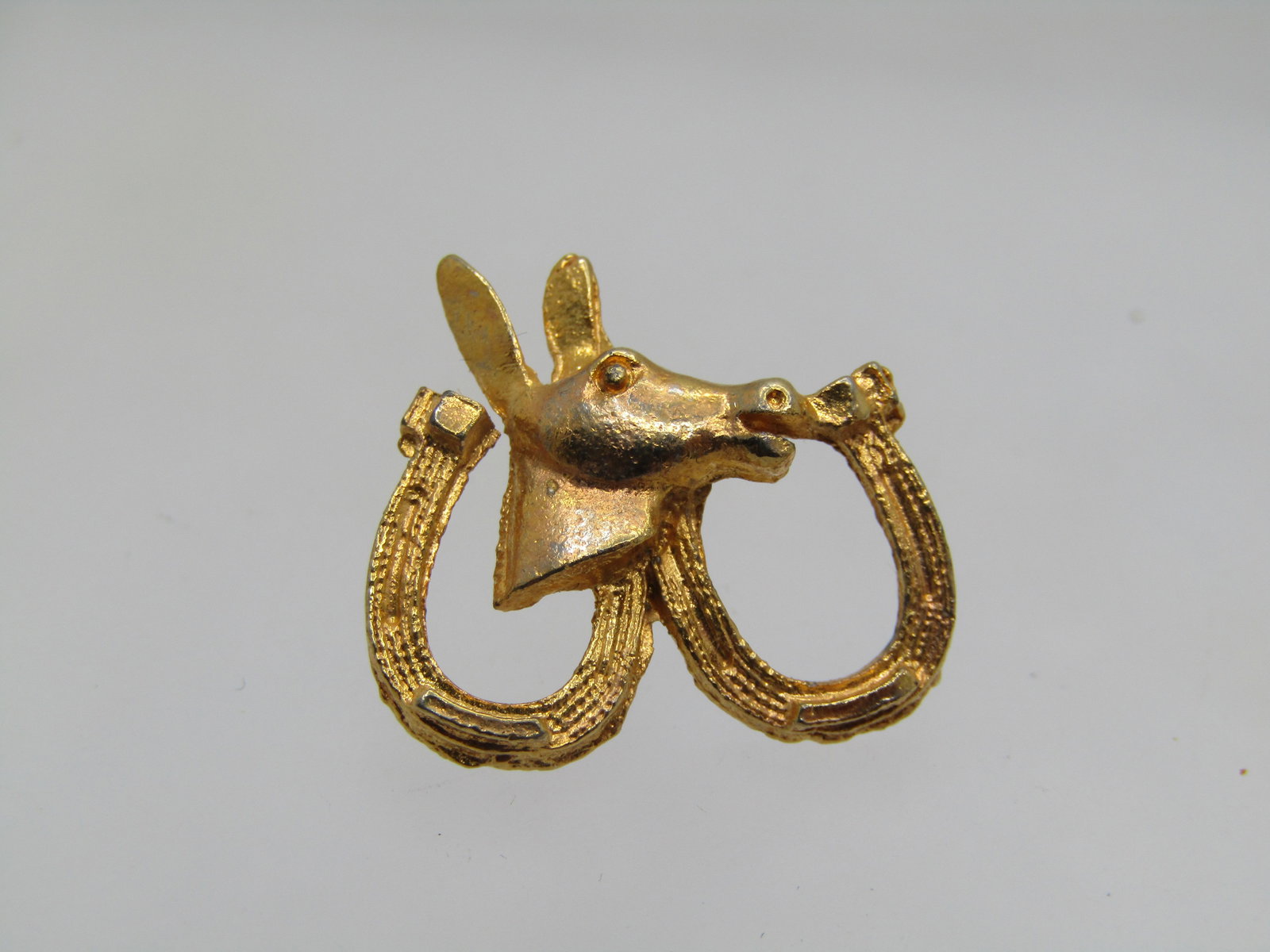 Vintage Horseshoe & Donkey Tack Pin, 1960's-1970's, Political: Vintage Horseshoe & Donkey Tack Pin, 1960's-1970's. Brushed finish on this gold tone political themed brooch. Two horseshoes with a donkey head in the center. It is appx. 7/8" wide and 3/4" tall. 