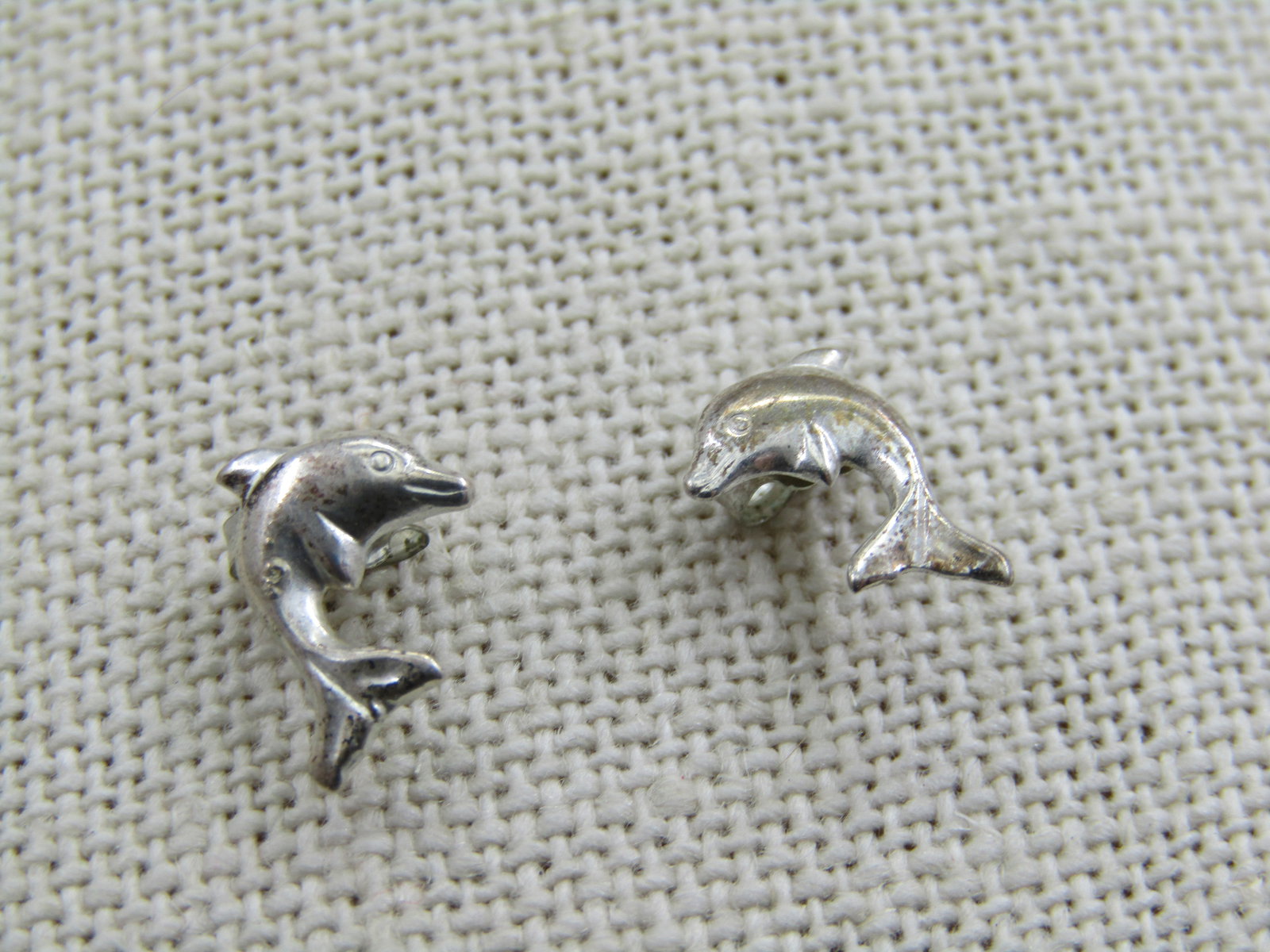 Sterling Silver Dolphin Earrings, Pierced, 1/2": Sterling Silver Dolphin Earrings, Pierced, 1/2". They are i a arched position as if they are jumping out of water. Marked sterling and are appx. .42 grams for the two fo them. Very good condition.
