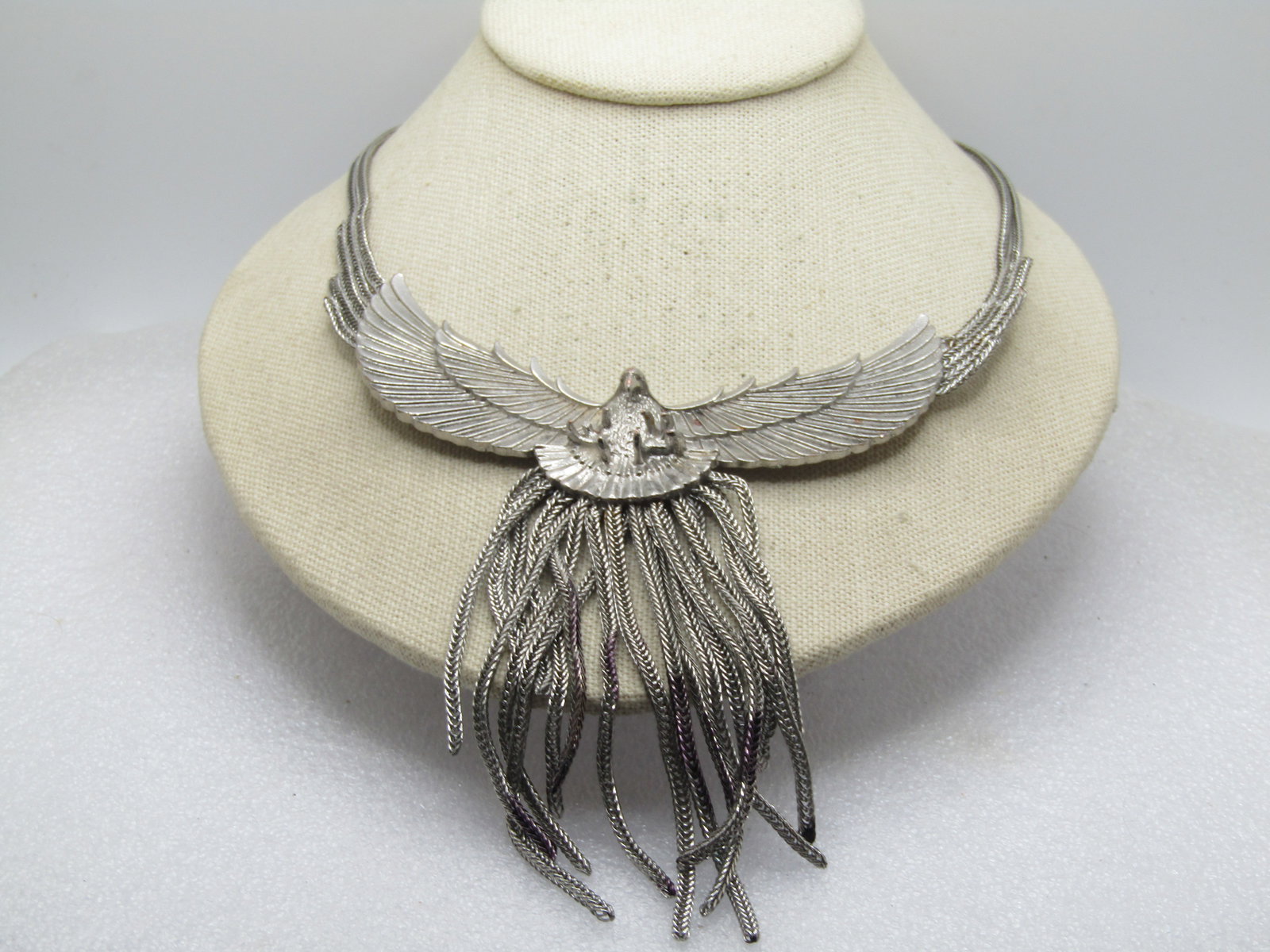 Vintage Wide Wing Eagle Necklace, Tassel Drop. 17", 1980's: Vintage Wide Wing Eagle Necklace, Tassel Drop. 17", 1980's. It is 14" with 3" extender chain. There are four silver tone foxtail chain lengths on the sides of the wings - two of which continue to