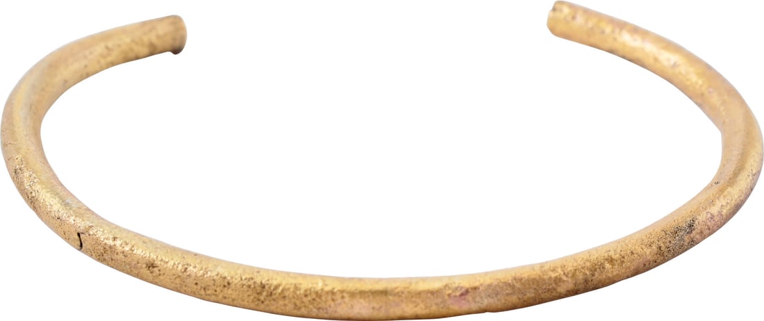 ROMAN WOMAN’S BRACELET, 1ST-3RD CENTURY AD.: Gilt bronze. Over 2 ½” (2.56”) inside dimension, C form, circular section expanding toward the terminals. Surface textured from burial. Professionally refurbished with the 24karat gol