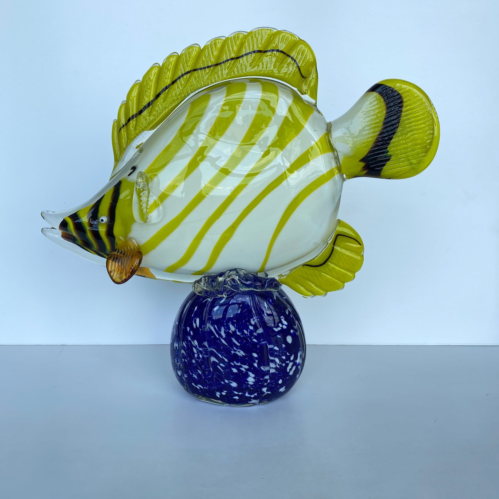 Blown glass fish on a pedestal: Title: Blown glass fish on a pedestalMaker:UnknownOrigin: UnknownDate/Period:UnkownMaterials:GlassSize:Size: 32 x 20 x 13 cmDescription:Blown glass fish on a pedestalSize: 30 x 32 x 10 cmWeight: 4090