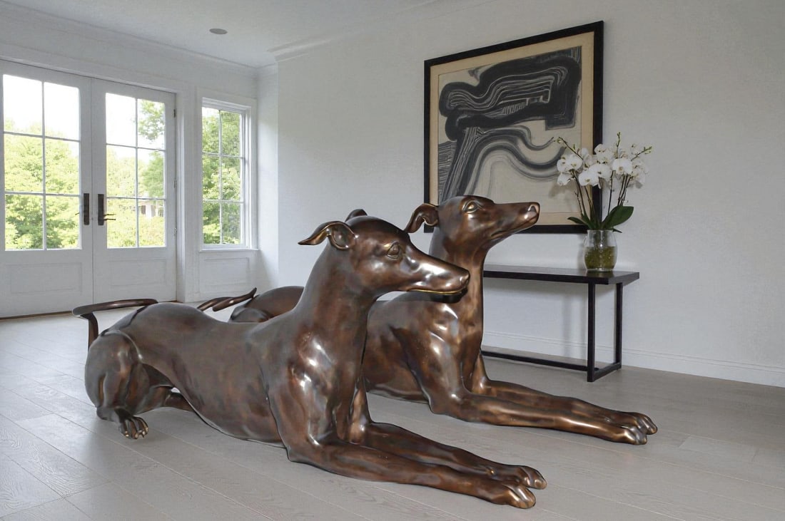 Pair of Greyhound dogs laying down Bronze Statues - Size: 50"L x 11"W x 20"H. - 3