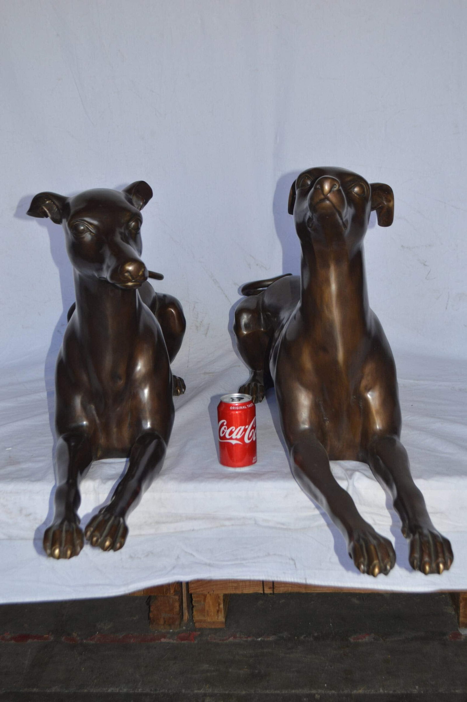 Pair of Greyhound dogs laying down Bronze Statues - Size: 50"L x 11"W x 20"H. - 5