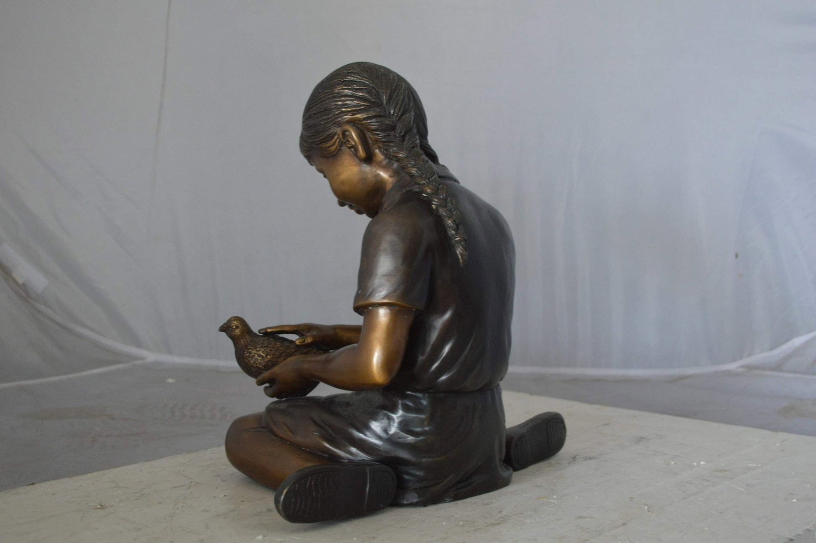 Young seated girl with bird bronze statue - Size: 12"L x 9"W x 14"H. - 9