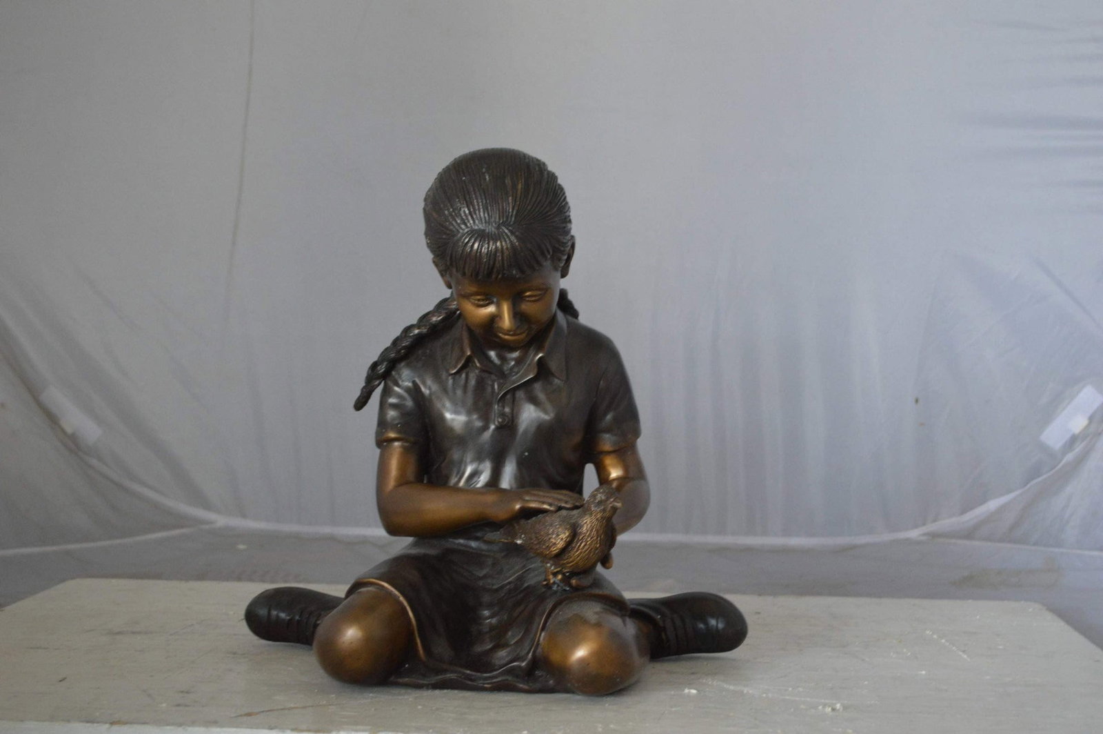 Young seated girl with bird bronze statue - Size: 12"L x 9"W x 14"H. - 5