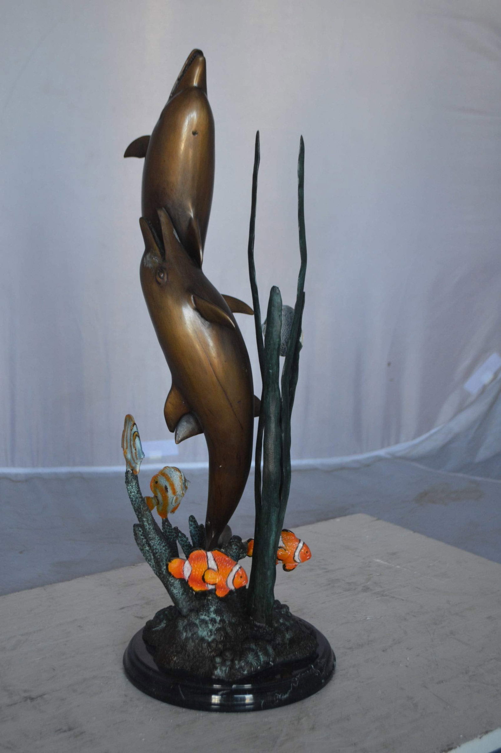 Two dolphins with fish, table top bronze statue. - Size: 8"L x 8"W x 22"H. - 8