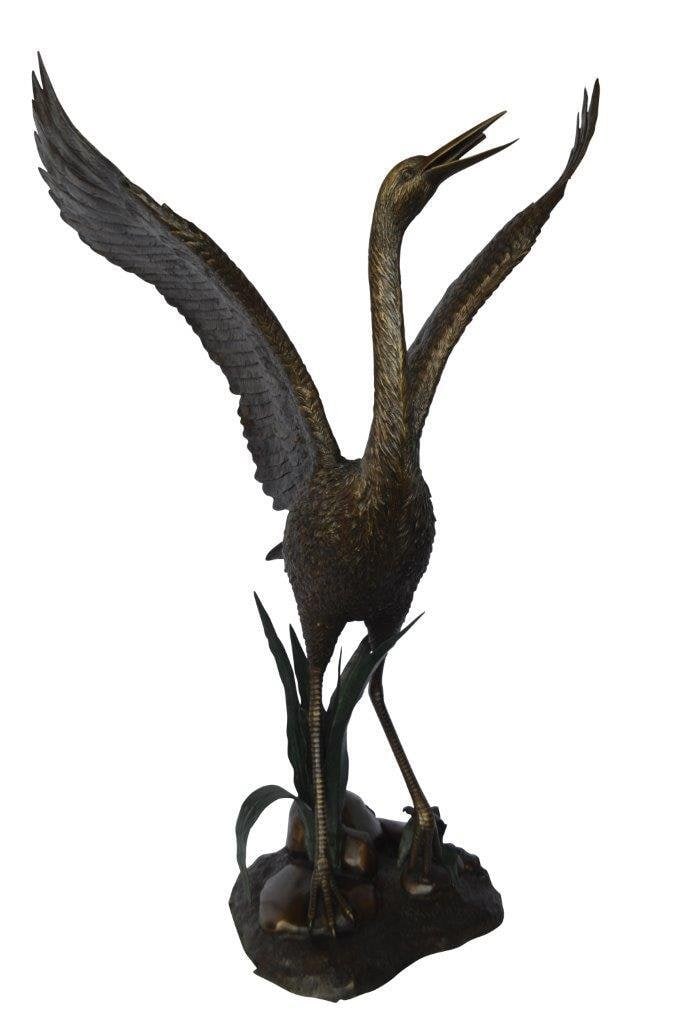 Crane standing on a stone bronze statue - Size: 28"L x 32"W x 49"H.: Title:Crane standing on a stone bronze statue - Size: 28"L x 32"W x 49"H. Description:A painted bronze crane with very fine naturalistic color and details. He is ready to take off and fly Like those s