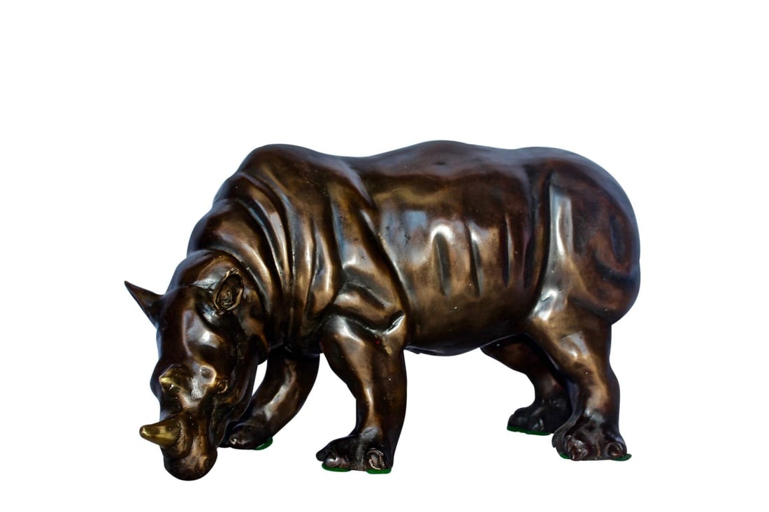 Relaxed Rhino bronze statue - Size: 16"L x 9"W x 8"H.: Title:Relaxed Rhino bronze statue - Size: 16"L x 9"W x 8"H.Description:This statue of a relaxed rhino with his head learning down illustrates a rhino in a calm state on shore. Each line and detail in