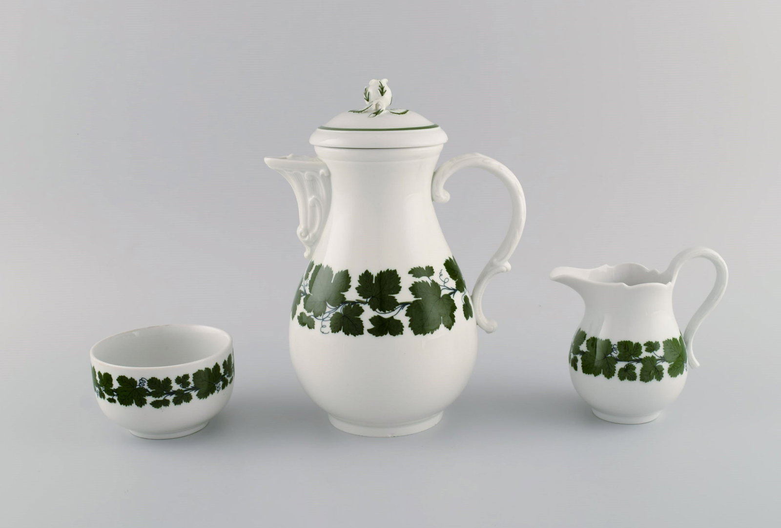 Meissen Green Ivy Vine. Coffee pot, sugar bowl and creamer in hand-painted porcelain. Lid modeled: Title: Meissen Green Ivy Vine. Coffee pot, sugar bowl and creamer in hand-painted porcelain. Lid modeled with rose bud. 1940's. Description: Meissen Green Ivy Vine. Coffee pot, sugar bowl and creamer