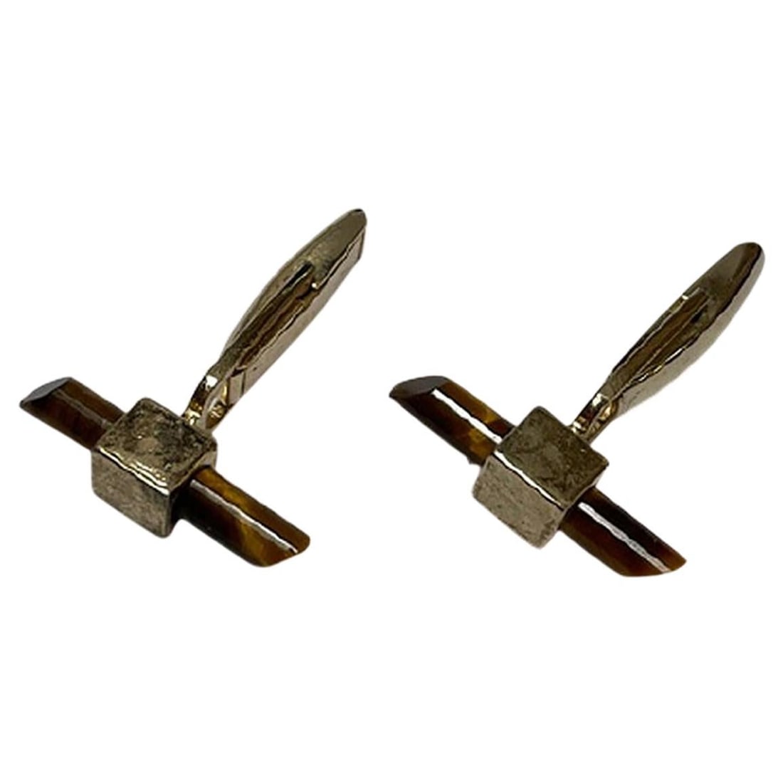 Tiger's Eye Cufflinks: Title: Tiger's Eye Cufflinks Description: These gold cufflinks feature tiger's eye gemstones, which have been formed into power rods. The gemstones have a beautiful gold and brown sheen to them, even