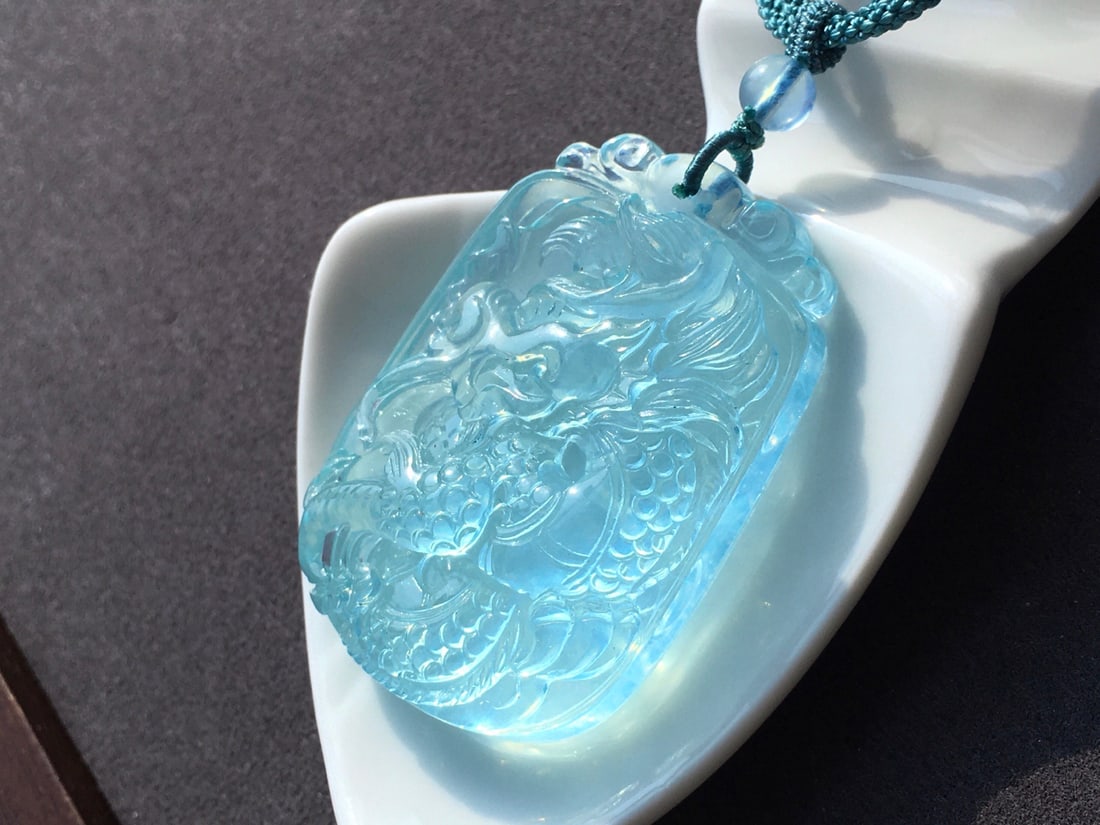 Natural Aquamarine Hand-Carved Dragon Pendant with Certificate: Title: Natural Aquamarine Hand-Carved Dragon Pendant with Certificate Origin: Chinese Date/Period: After2025 Materials: Aquamarine Dimensions: 44.2x30.6x11(mm) 1.74x1.20x0.43(inches) Weight 0.06