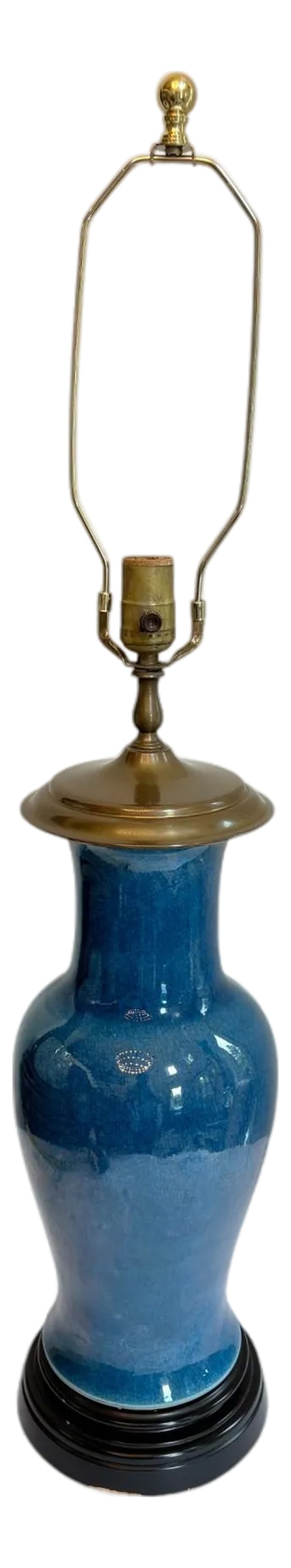 Wildwood Blue Porcelain Lamp: Wildwood Blue Porcelain Lamp This urn shaped lamp has a circular wood base and brass tone top. The blue porcelain base has a crackle appearance and is a rich color. There is a round finial on the harp