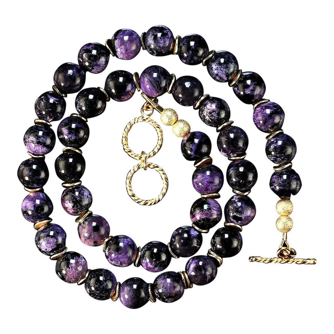 Purple Charoite Necklace With Goldy Accents: This is part of Chairish's Costume Jewelry assortment. Description: Elevate your style with this exquisite 20-21 inch expandable Charoite necklace, featuring smooth, highly polished 10mm beads that sh