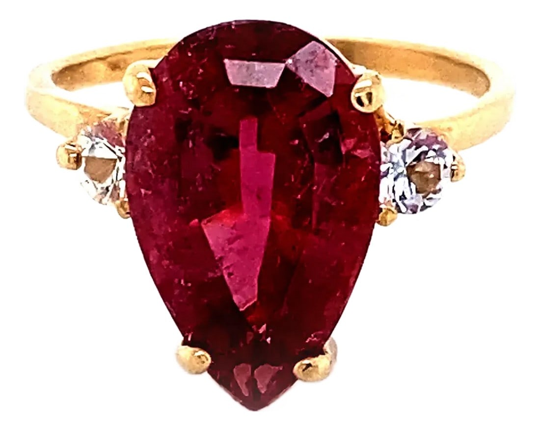 Sparkling Pinky/Red Rubelite & White Sapphires in 14k Gold Ring: This stunning ring features a sparkling Brazilian step-cut pear-shaped Rubelite, accentuated by two brilliant White Sapphires, all set in luxurious 14K yellow gold. The 4.5-carat Rubelite, with