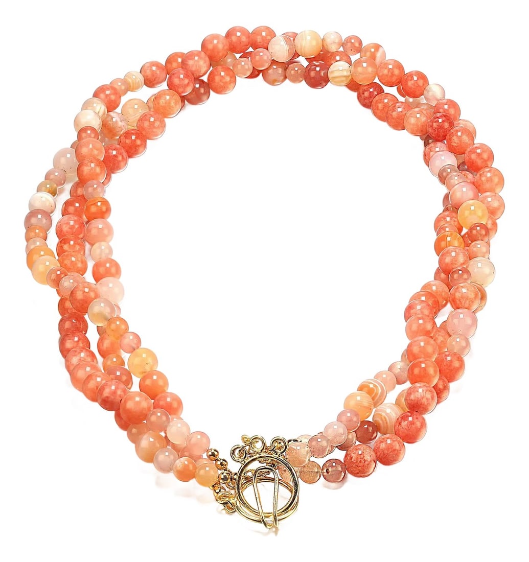 Three Strand Coral Agate Necklace: Three-Strand Coral Agate Necklace This beautifully crafted three-strand necklace features a vibrant array of coral agate beads, designed to add elegance to any outfit. Key Features: Length: 19