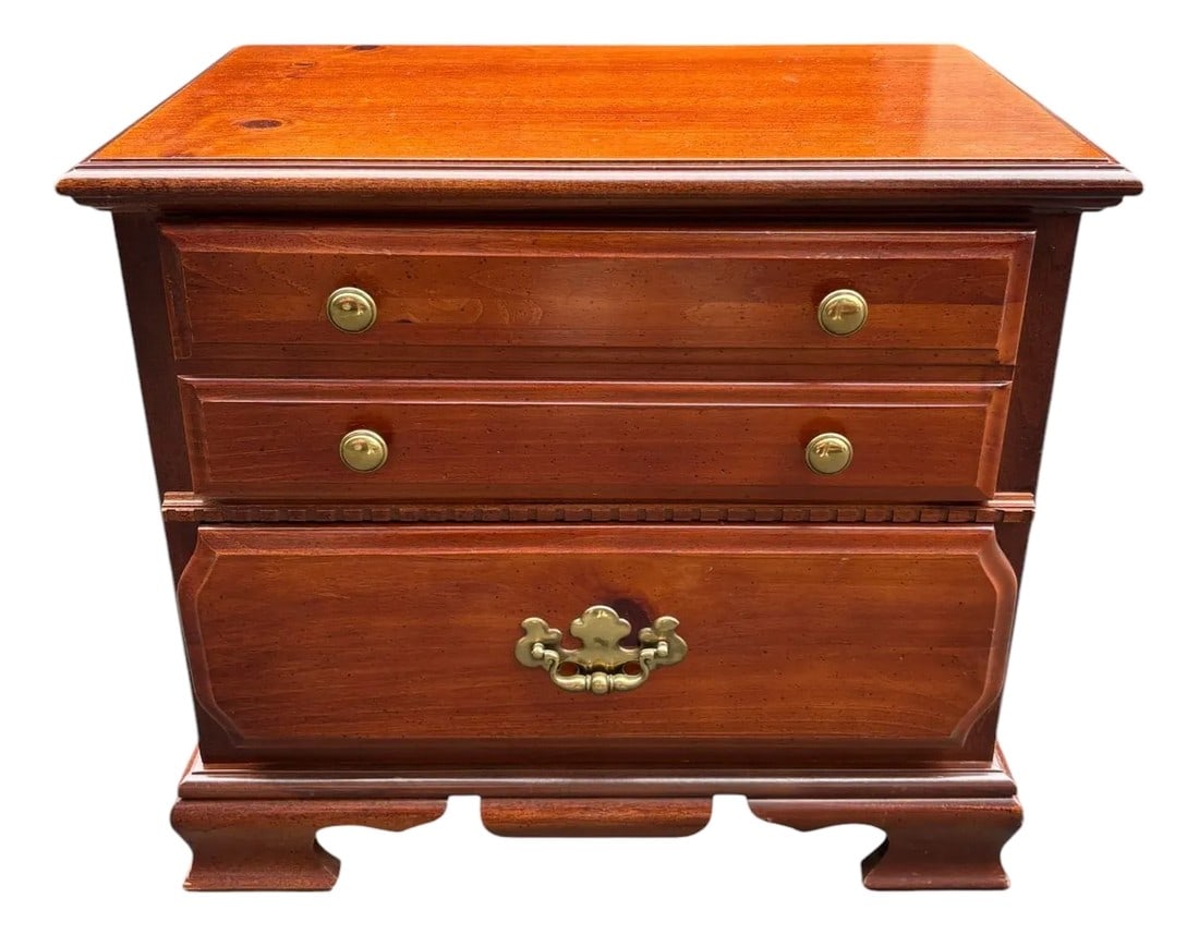 Bassett Chippendale Two Drawer Nightstand Chest: Quick Hits: Traditional Bassett craftsmanship Chippendale-style bracket feet and brass hardware Warm cherry-toned finish with subtle woodgrain Two drawers over a single deep drawer design Perfect as