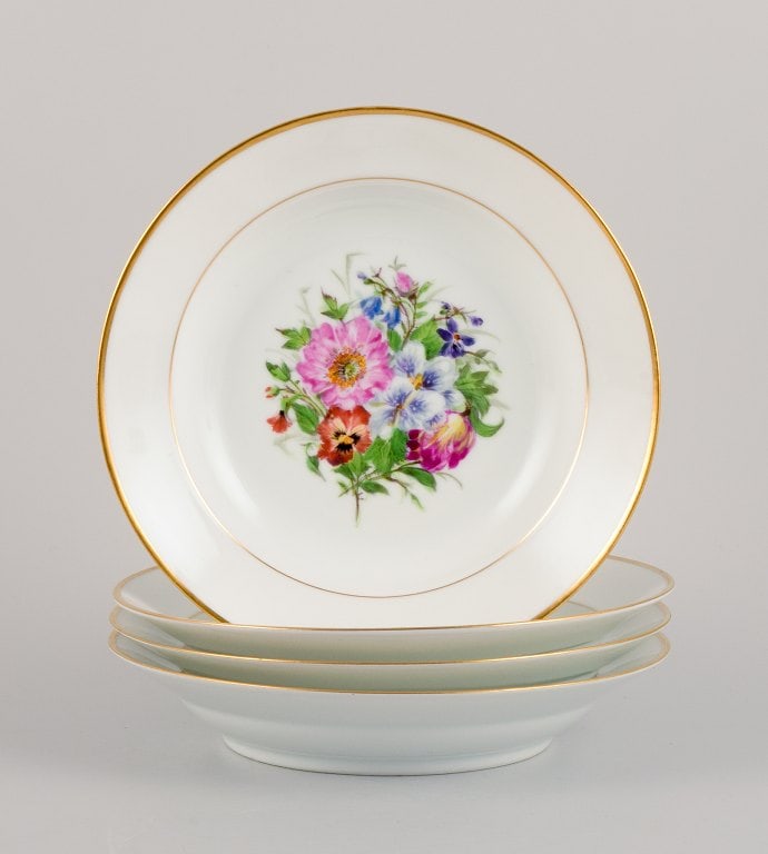 Bing & Grøndahl, four deep plates in porcelain hand-painted with polychrome flowers and gold: Bing & Grøndahl, four deep plates in porcelain hand-painted with polychrome flowers and gold decoration. 1920/30s. In excellent condition. Marked. First factory quality. Dimensions: D 21.0 cm. x
