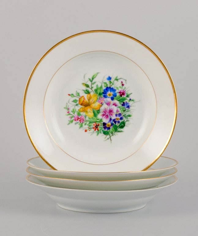 Bing & Grøndahl, four deep plates in porcelain hand-painted with polychrome flowers and gold: Bing & Grøndahl, four deep plates in porcelain hand-painted with polychrome flowers and gold decoration. 1920/30s. In excellent condition. Marked. First factory quality. Dimensions: D 21.0 cm. x