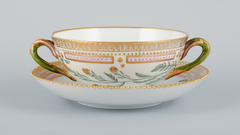 Royal Copenhagen Flora Danica boullion cup with saucer in hand-painted porcelain with branch-shaped: Royal Copenhagen Flora Danica boullion cup with saucer in hand-painted porcelain with branch-shaped handles, flowers and gold decoration. PROVENANCE : VALDEMARS CASTLE Reserve: $1,260.00 Shipping: Do