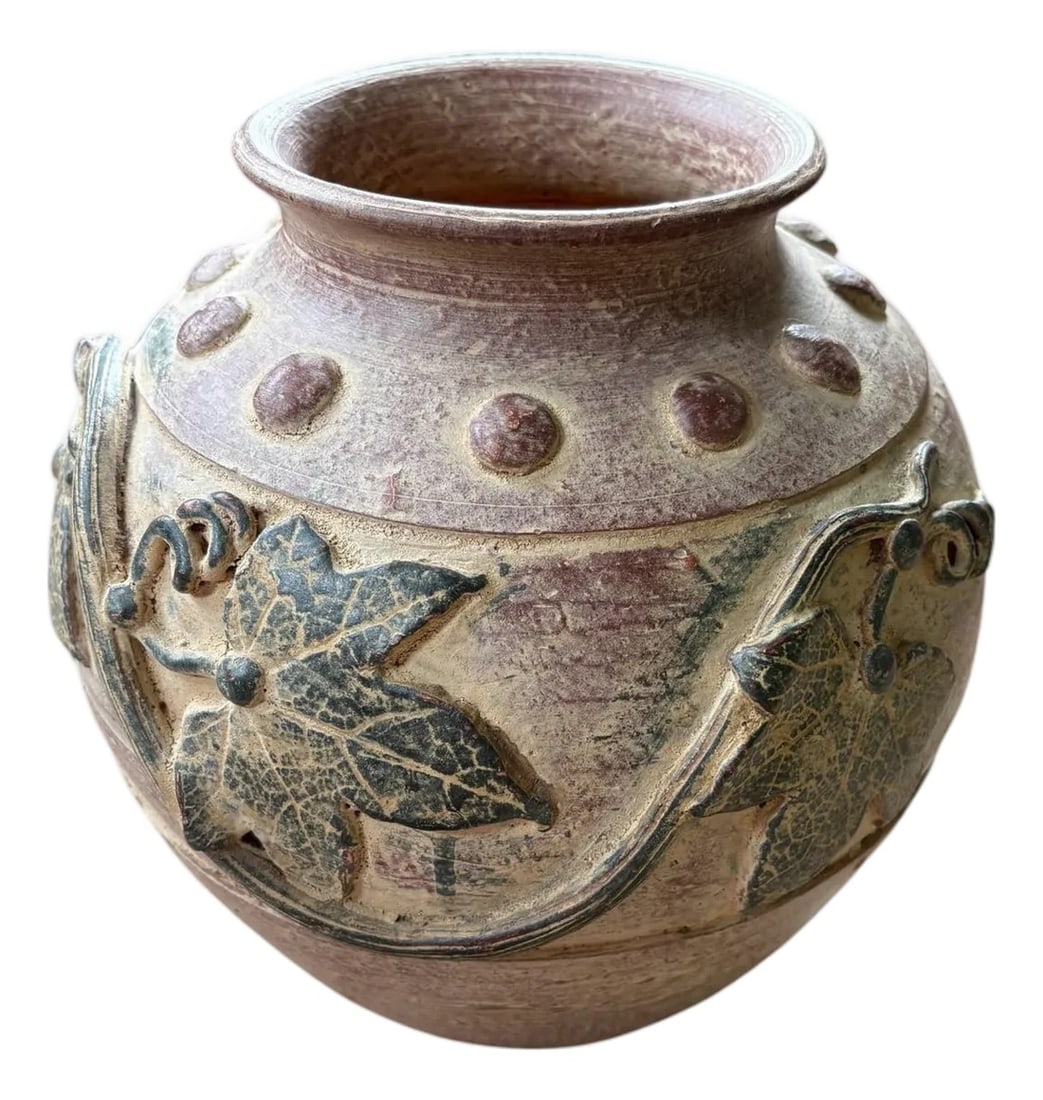 Wildwood Clay Jar With Leaves: This Wildwood clay jar features leaves and detail that give a nod to nature or even Tuscany. With an almost purple tone mixed into its natural base, the base measures 5.75" w/d. Button detailing lines